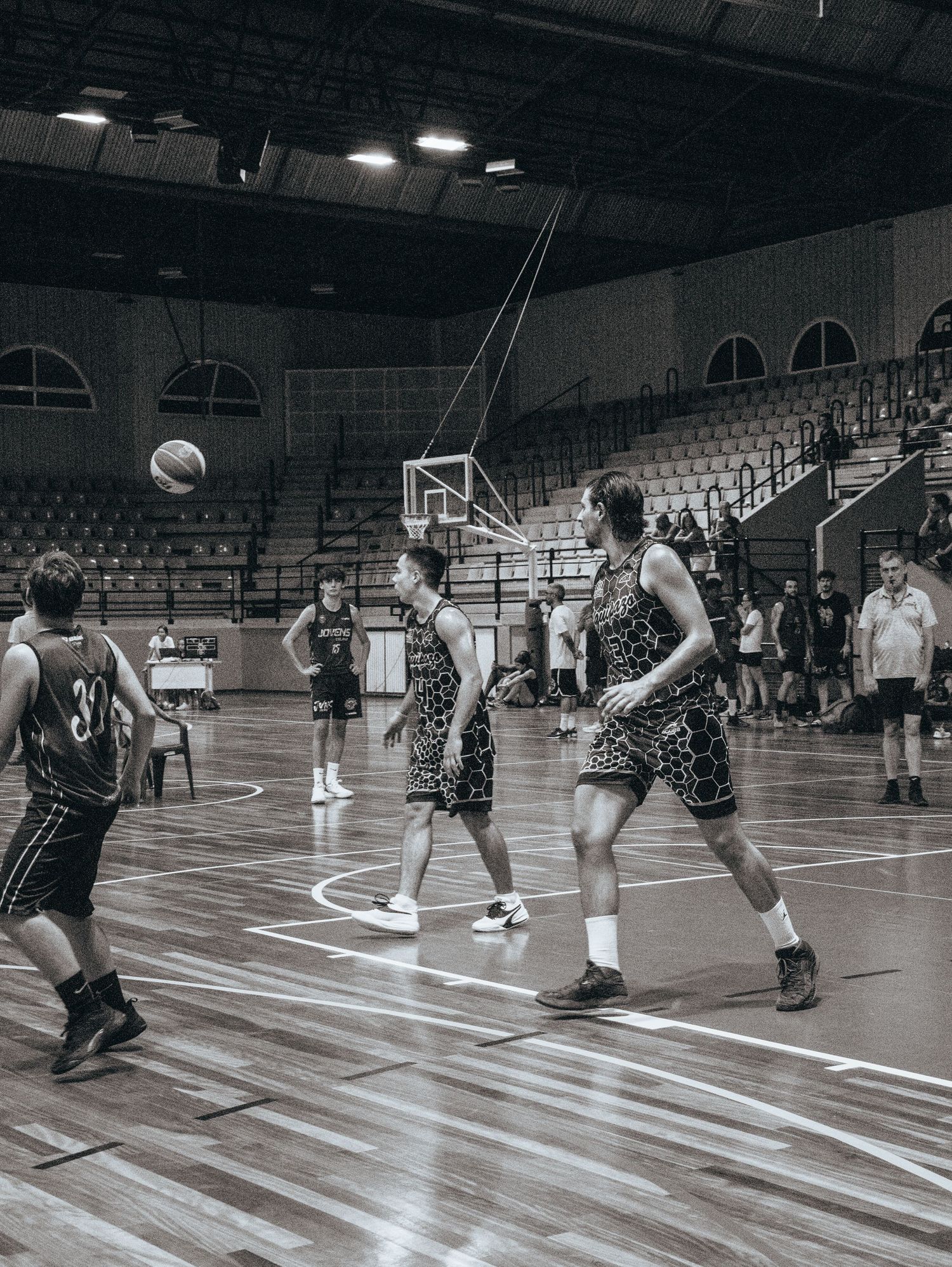 Basketball players diving for the ball during an indoor practice drill.