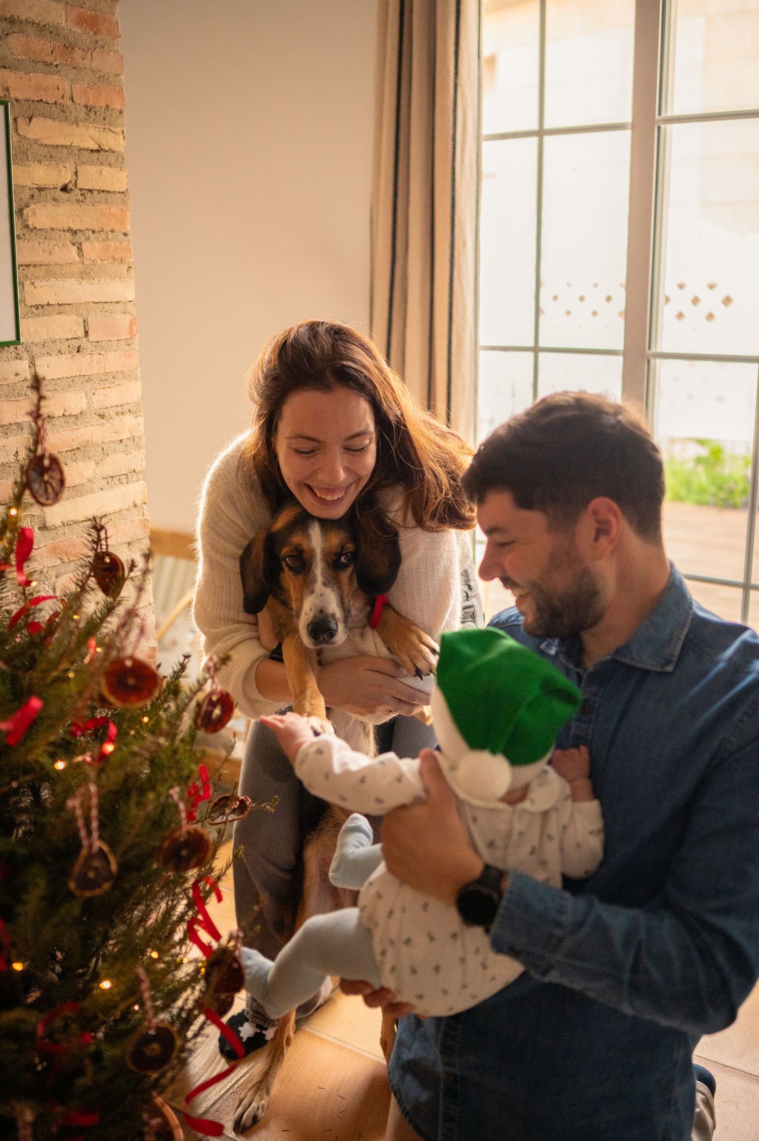 Family gathered around a decorated Christmas tree during the holiday season.