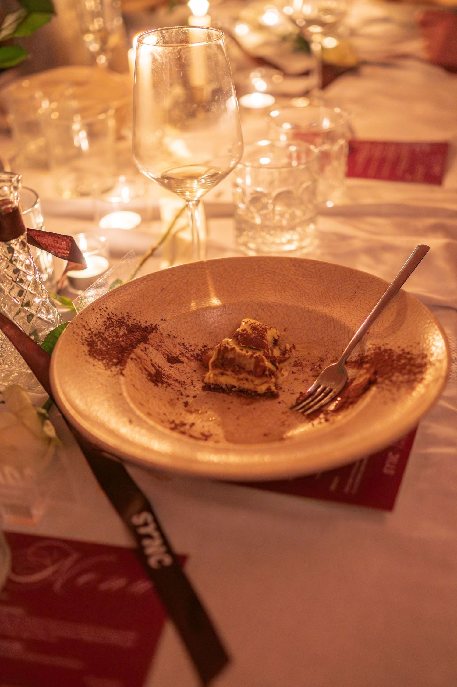 Empty plate with chocolate dessert remnants on an elegantly set dining table.