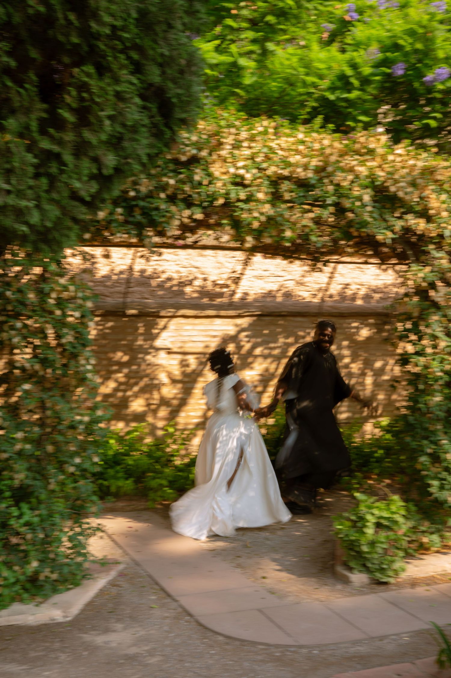 Wedding couple sharing intimate moments in lush garden setting.