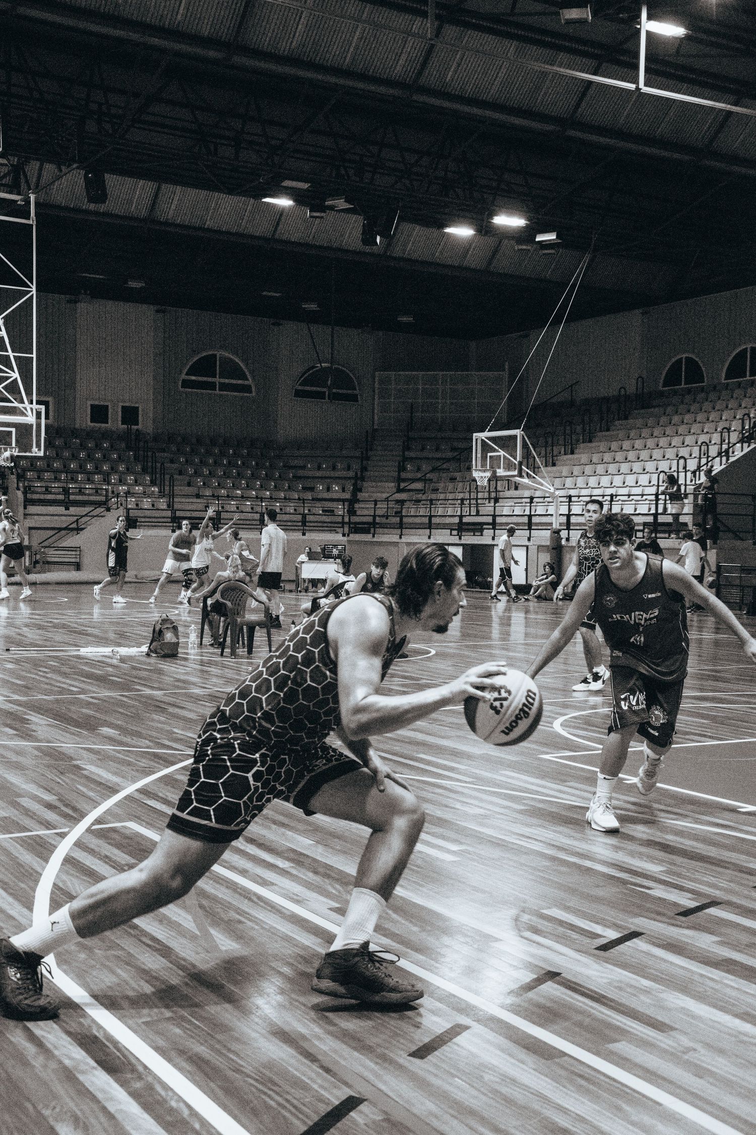 Athletes demonstrating defensive sliding techniques during basketball practice.