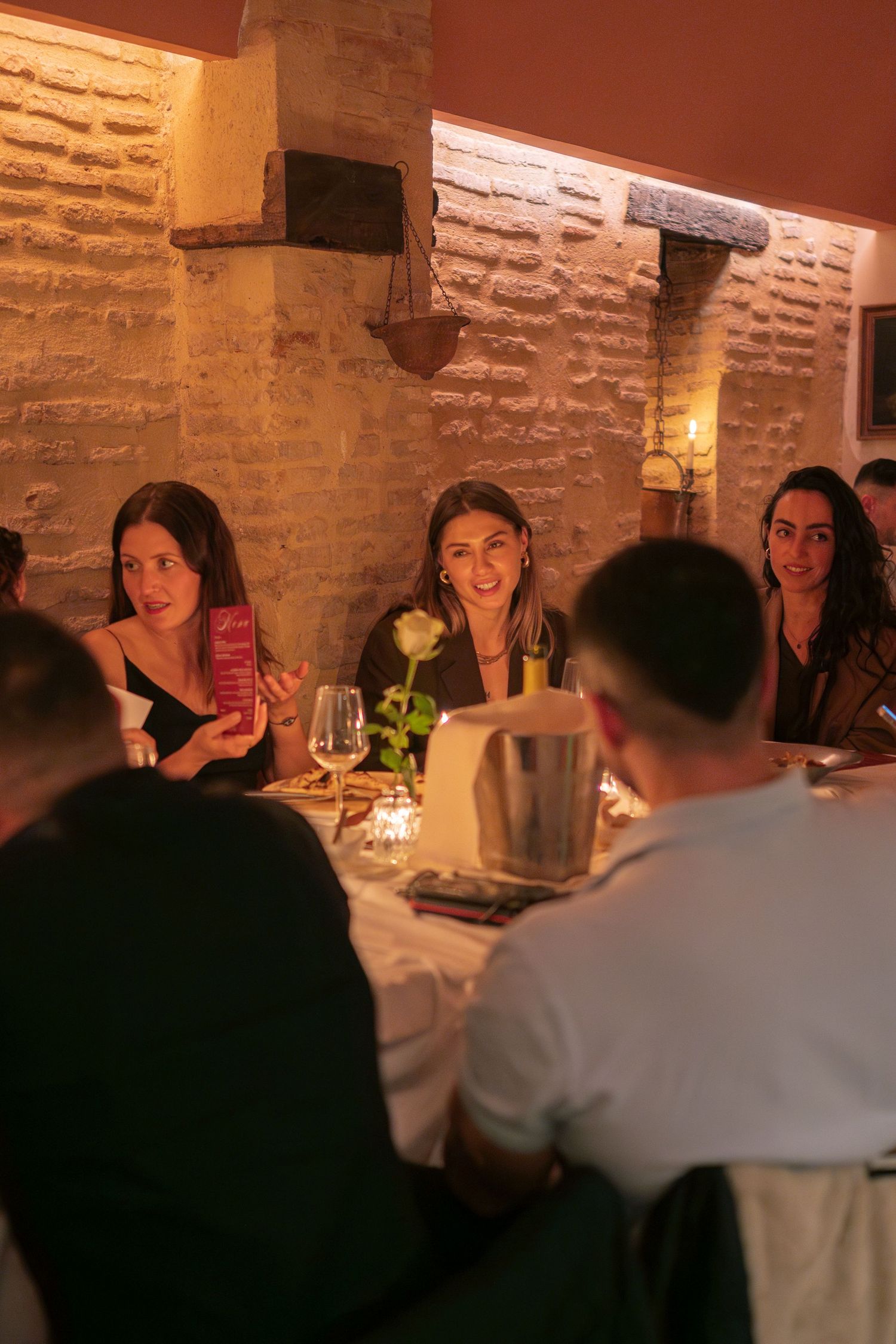 A cozy restaurant dinner scene with brick walls and intimate lighting.