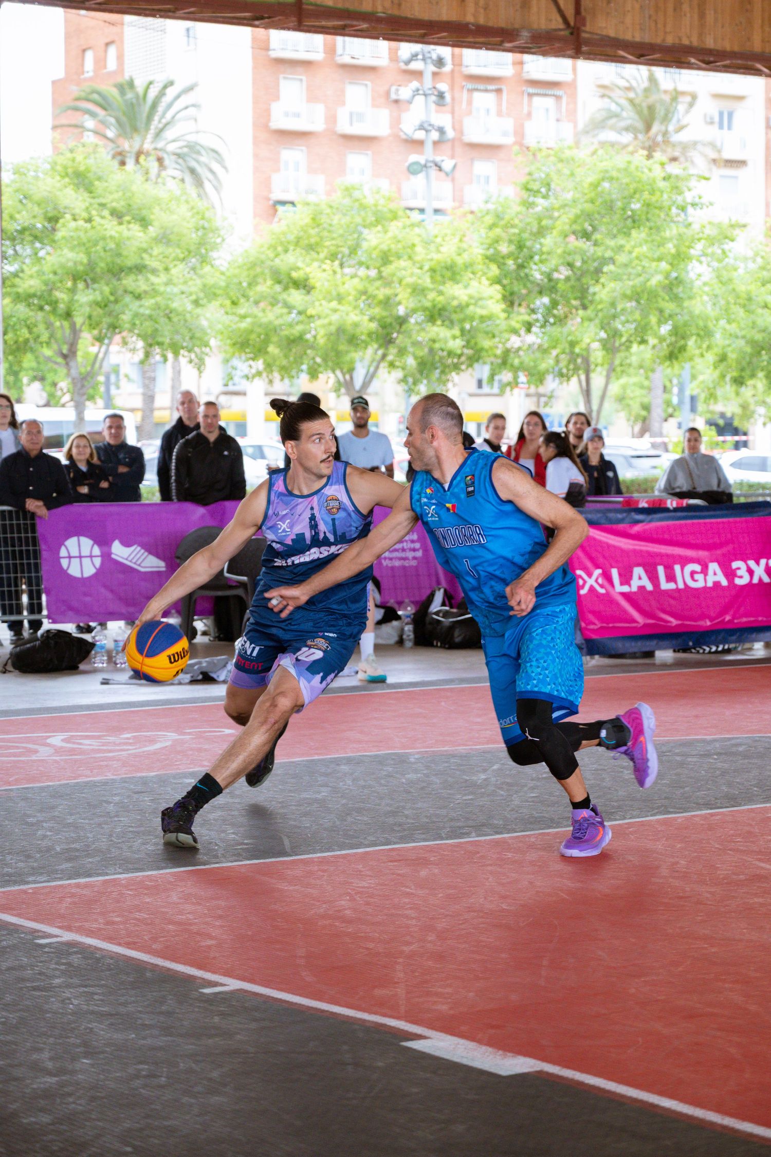 Two players in action during a competitive 3x3 basketball match on a red court.