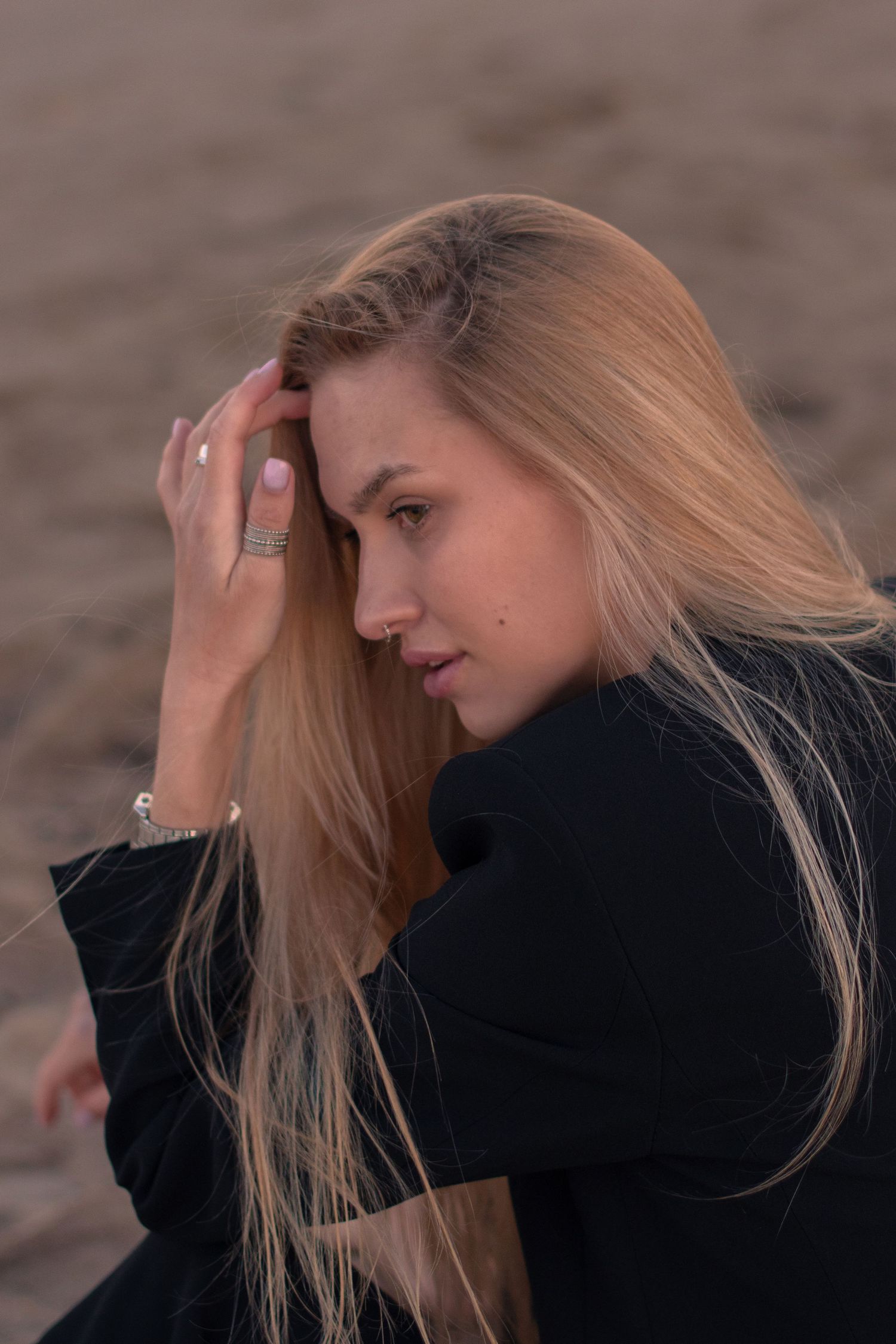 Woman with blonde hair wearing black poses dramatically in an artistic photoshoot sequence.