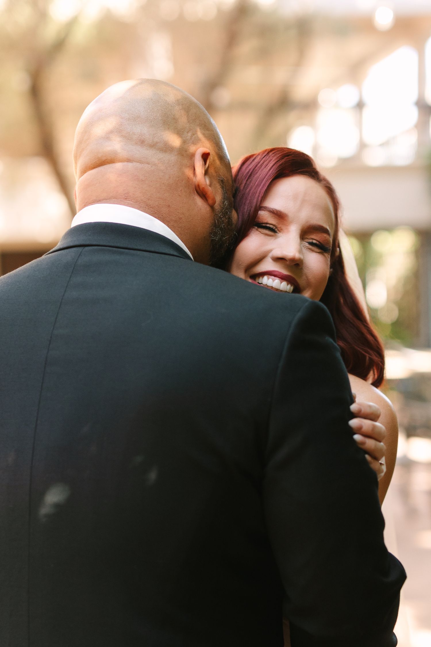 Intimate embrace between couple sharing emotional moment during wedding celebration.
