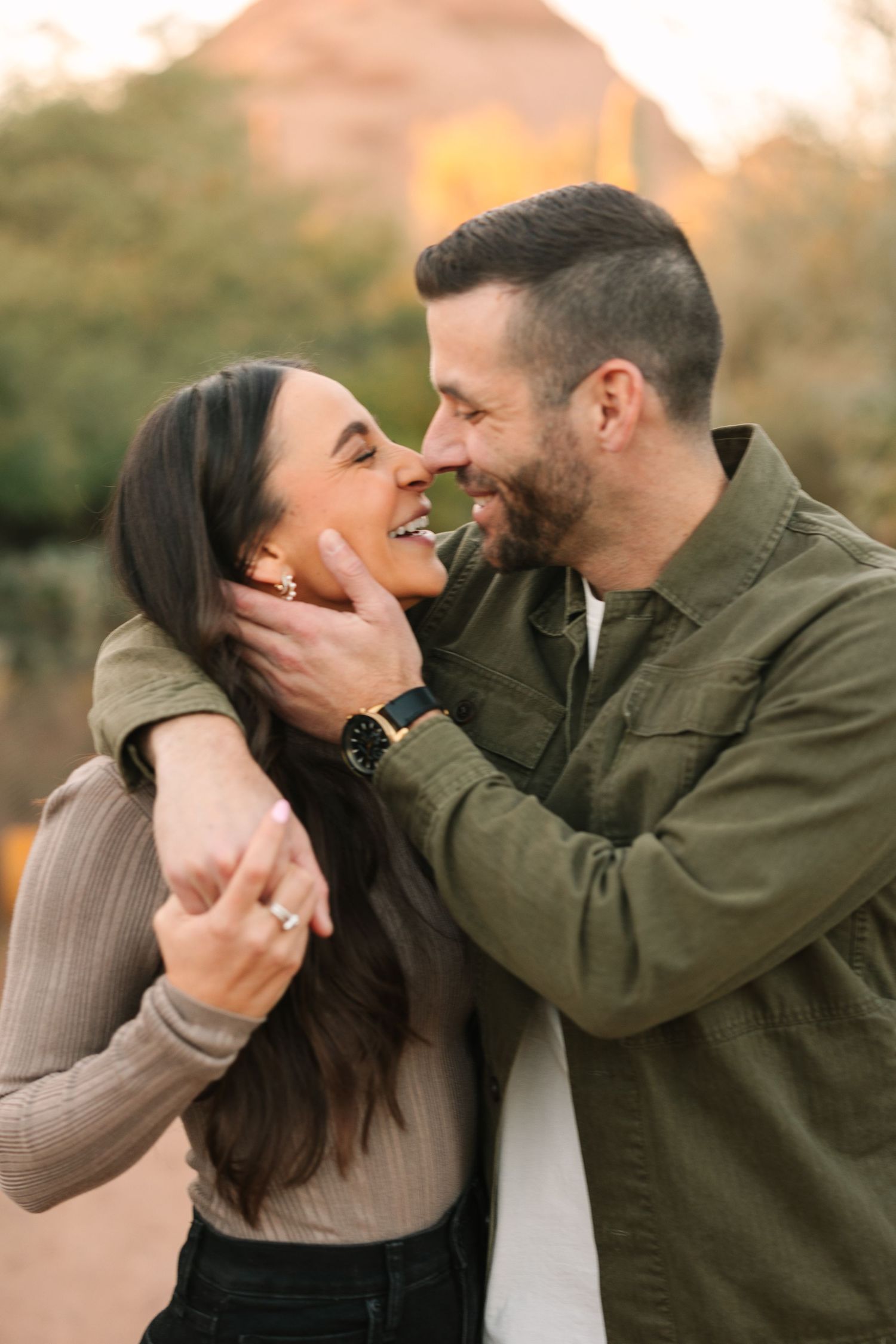 Romantic couple sharing intimate moments in an outdoor setting during golden hour lighting.