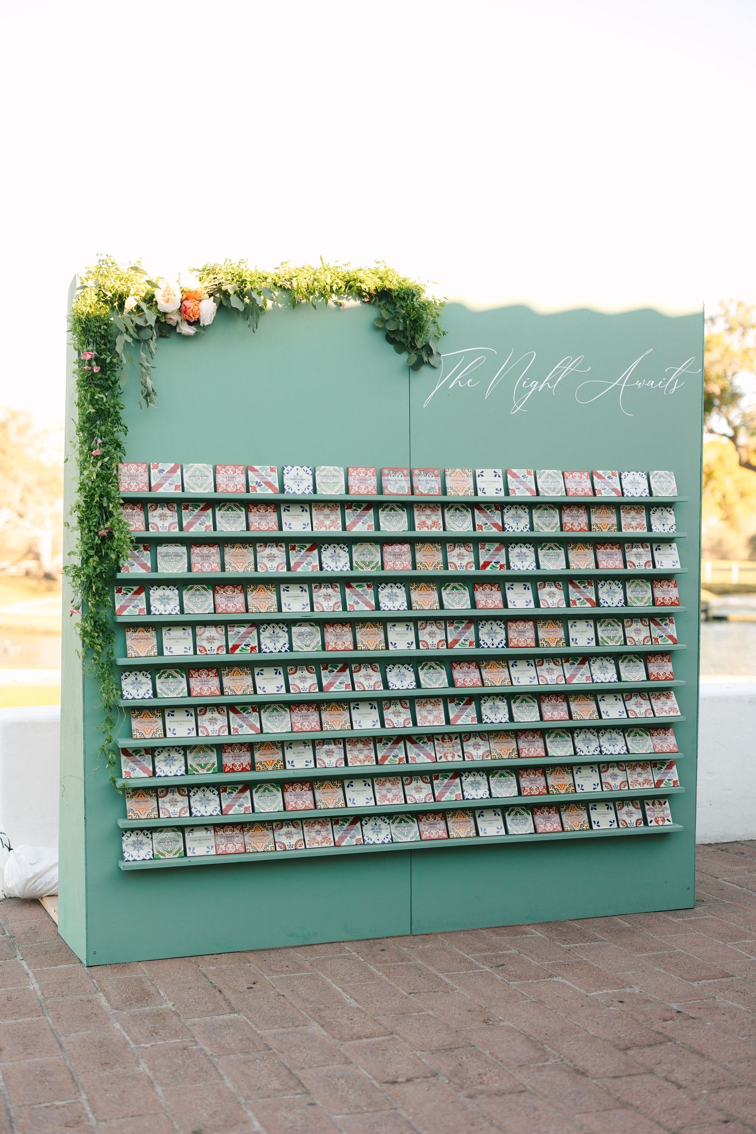 Mint green wedding seating chart display with floral accents and organized escort cards.