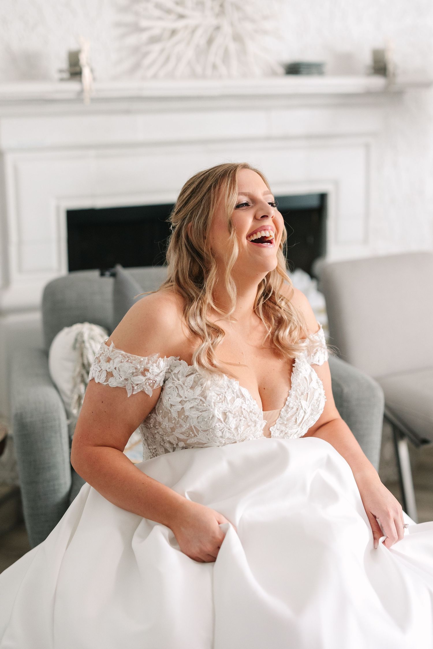 Joyful moments captured of a bride in a white lace dress against an elegant interior setting.