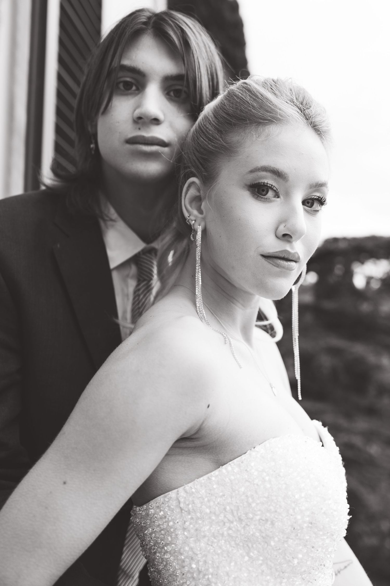 Artistic black and white wedding portrait capturing a romantic couple in formal attire.