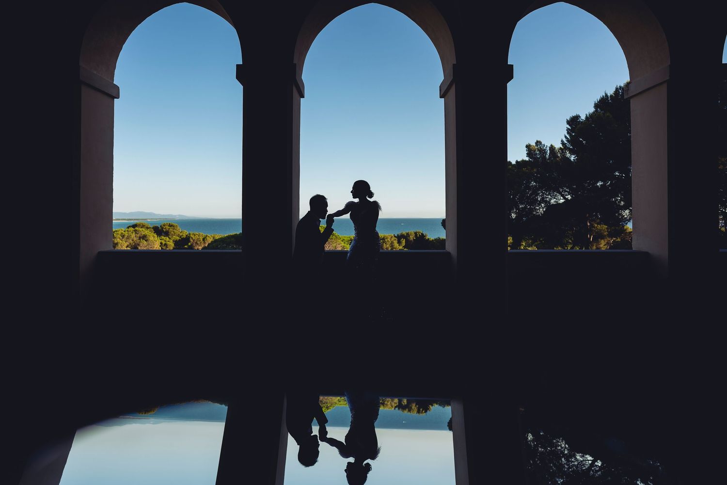 Elegant archways silhouetted against a bright blue sky creating dramatic architectural lines.