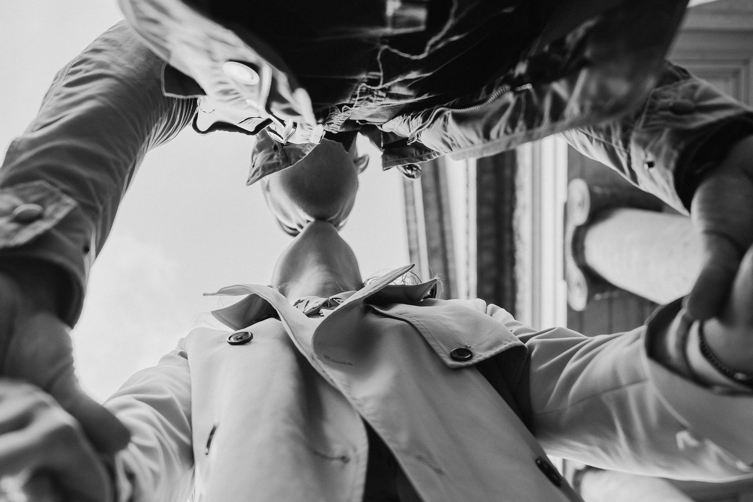 A black and white detail shot of hands adjusting formal attire.