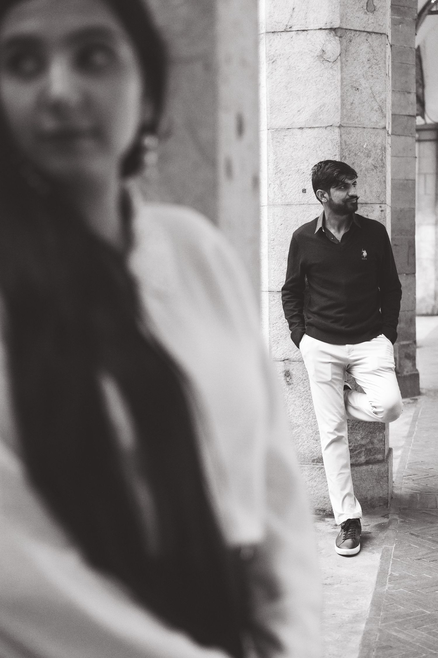 An artistic black and white photo capturing a couple in an architectural setting.