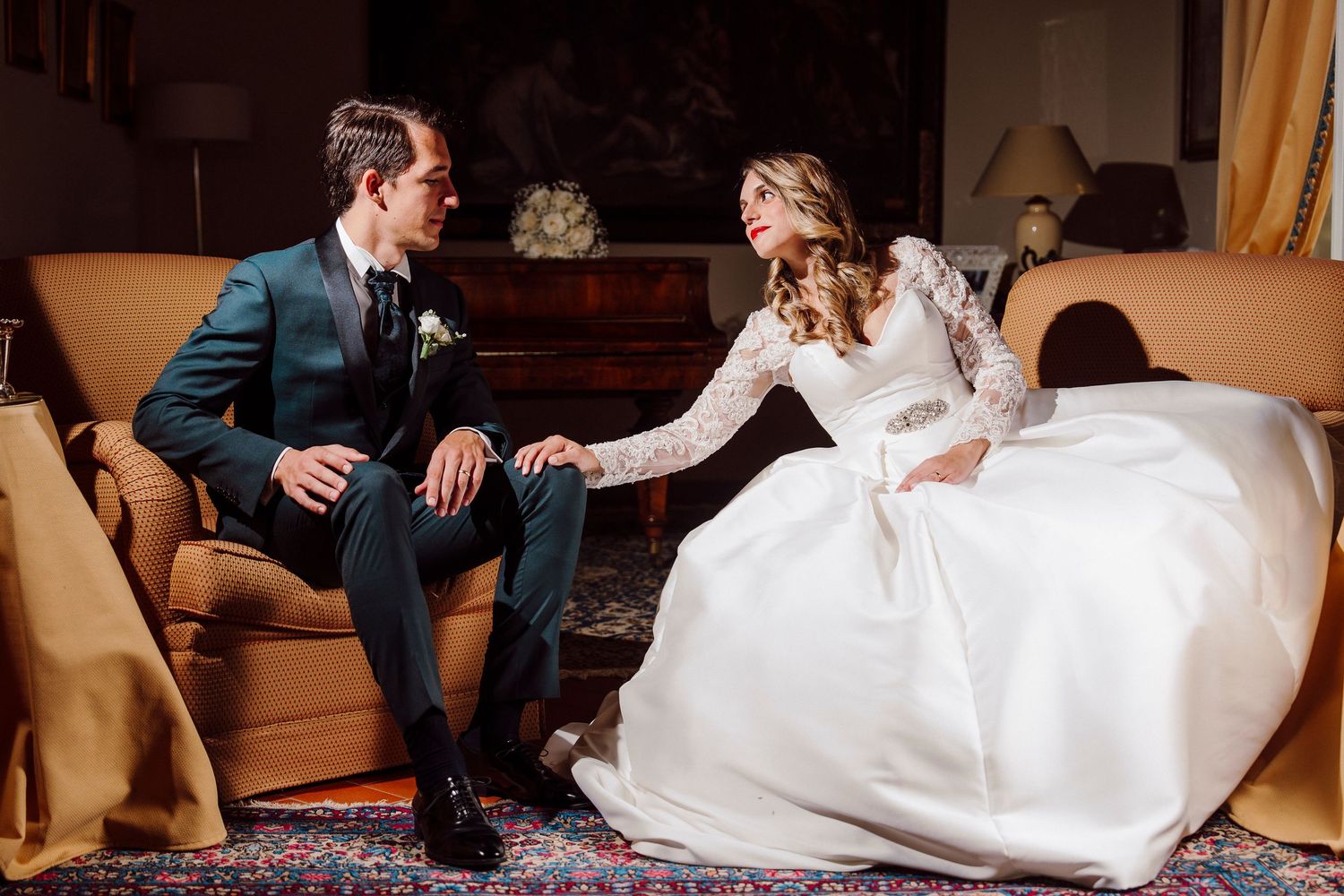 Romantic wedding scene with couple interacting on vintage furniture.