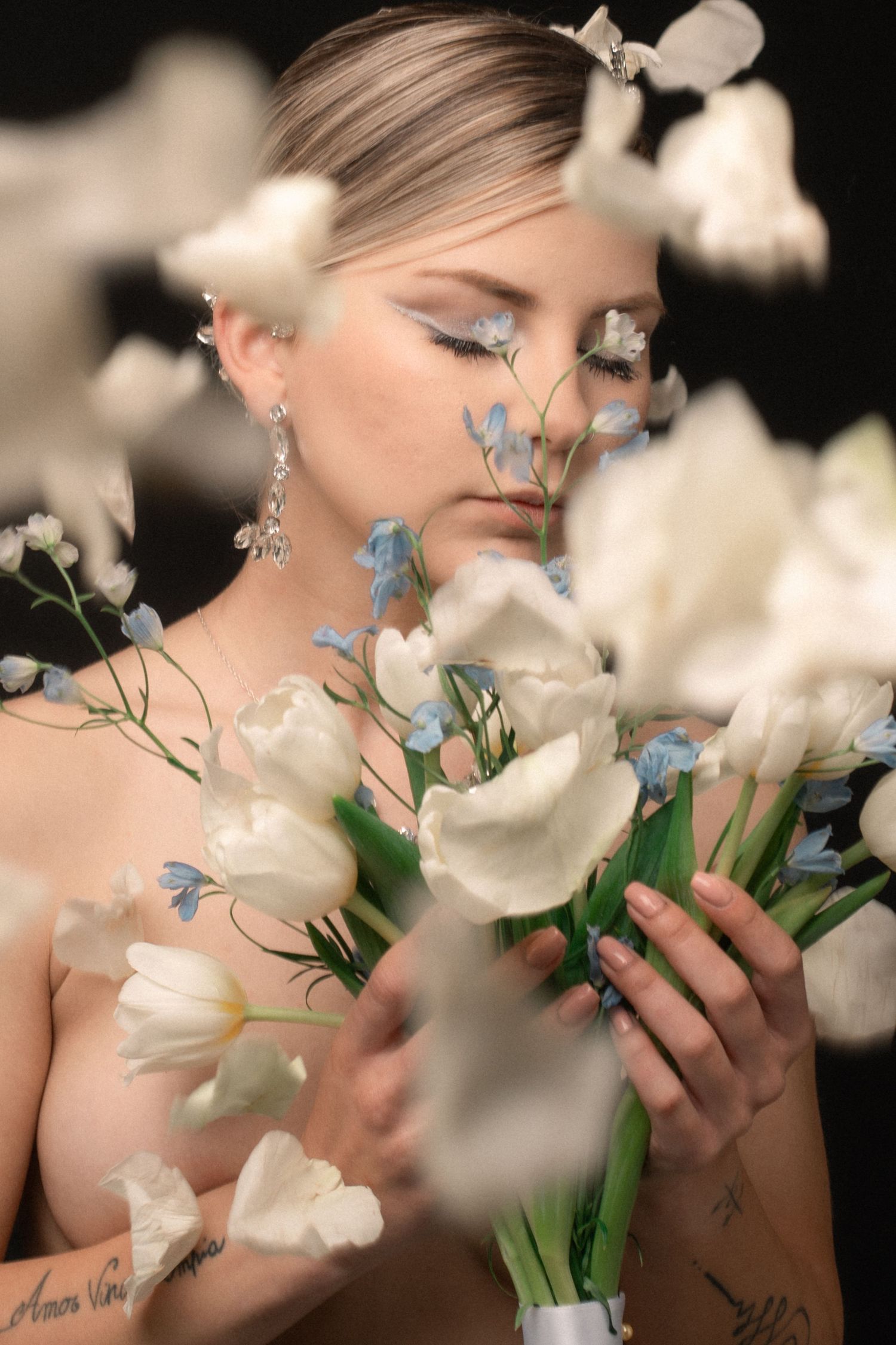 Romantic bridal portrait with white and blue flowers in soft focus.