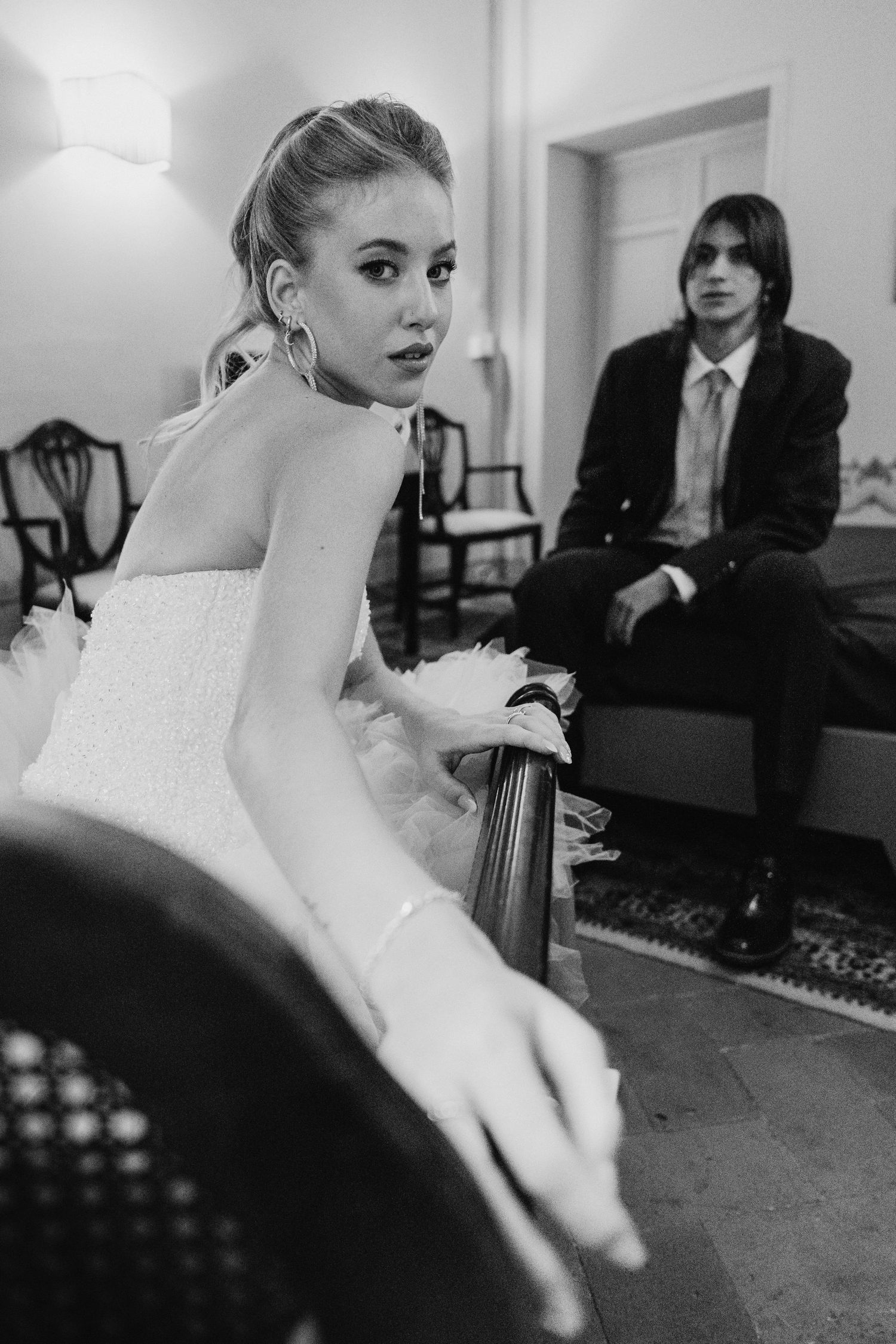 Black and white vintage-style wedding portrait in an elegant interior setting.