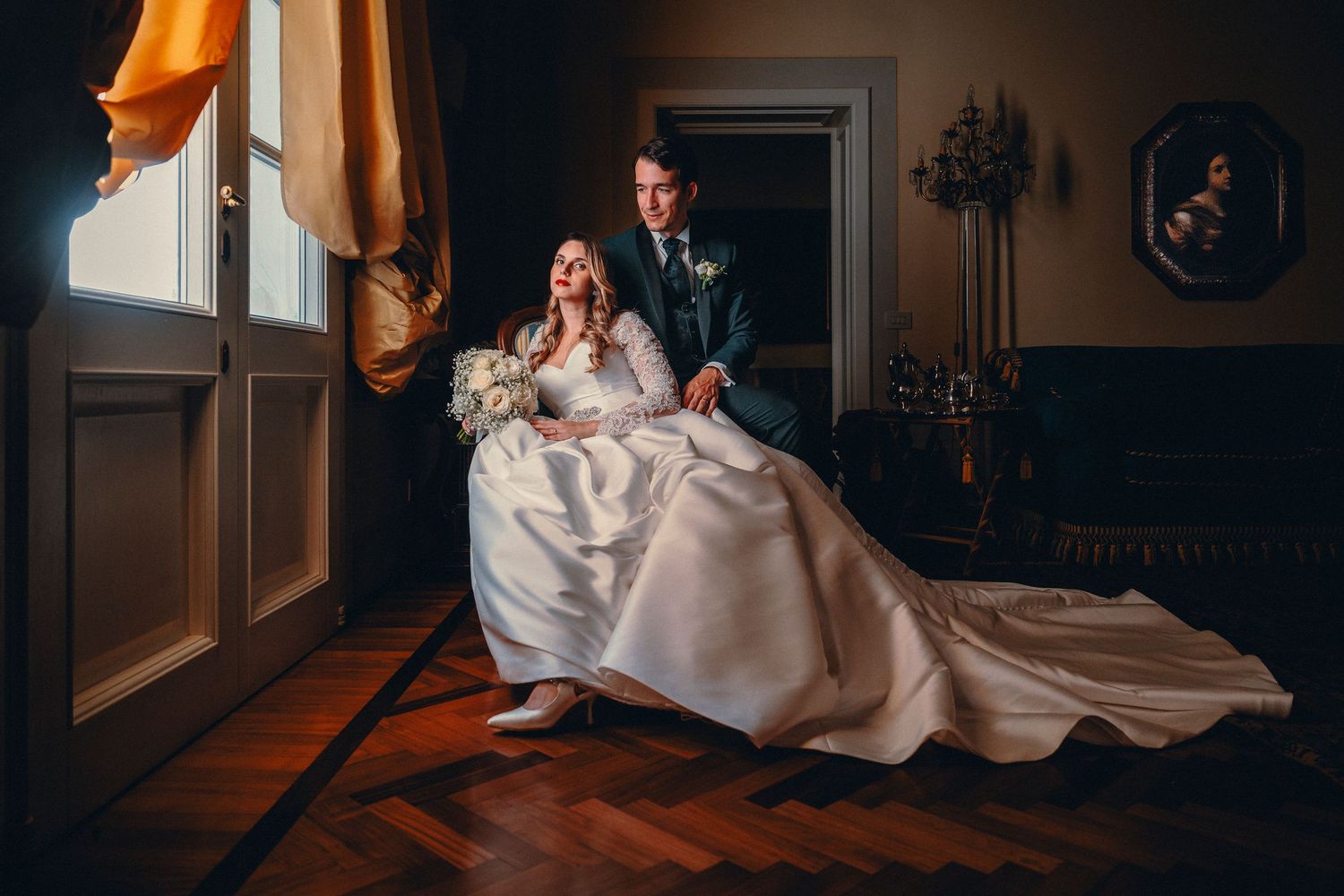 Elegant wedding portrait with natural lighting in a vintage room setting.