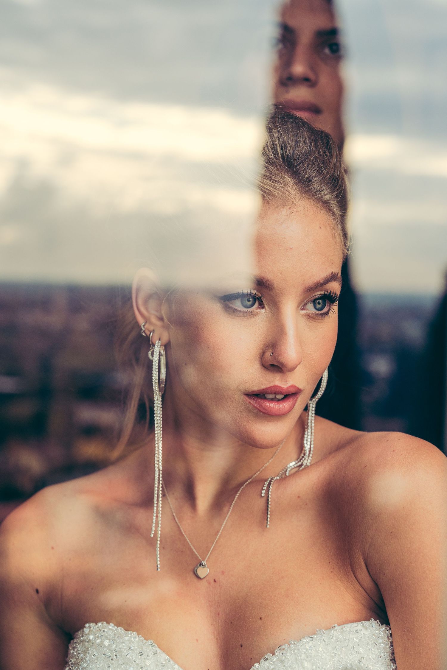 Elegant bridal portrait with dramatic lighting and dangling earrings.