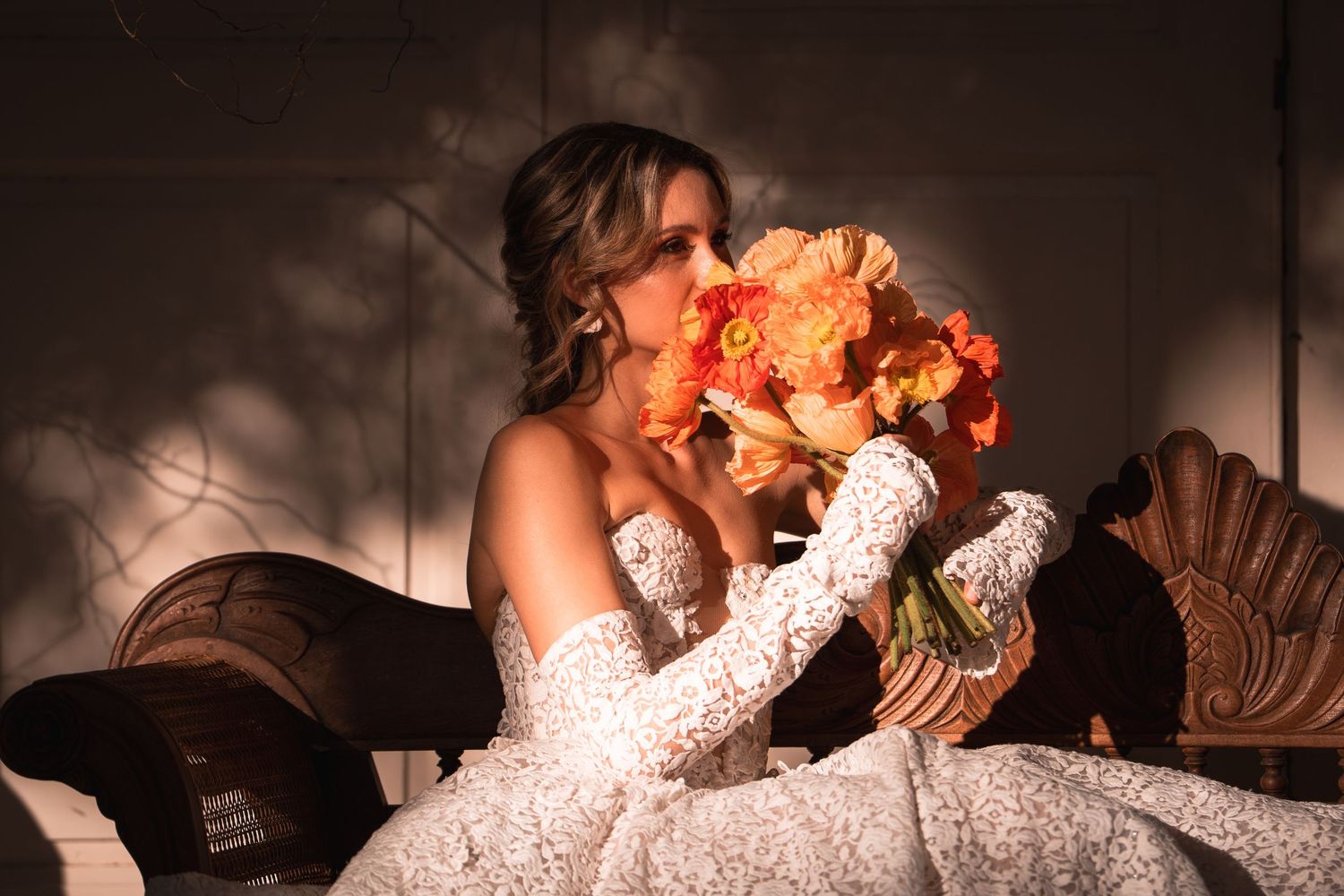 unique wedding moment with the bride sitting on a vintage wood sofa, surrounded by nature and decorative flowers.
