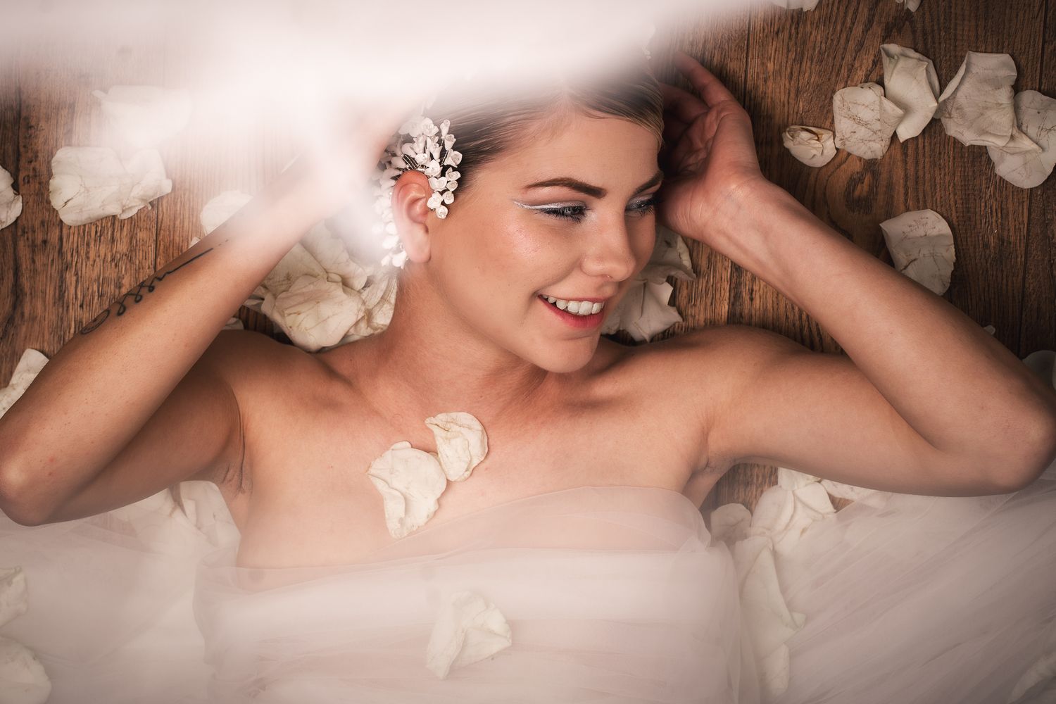 Studio image of a contemporary bride with bold roses and elegant accessories. A creative, fashion-inspired approach to wedding portraiture.