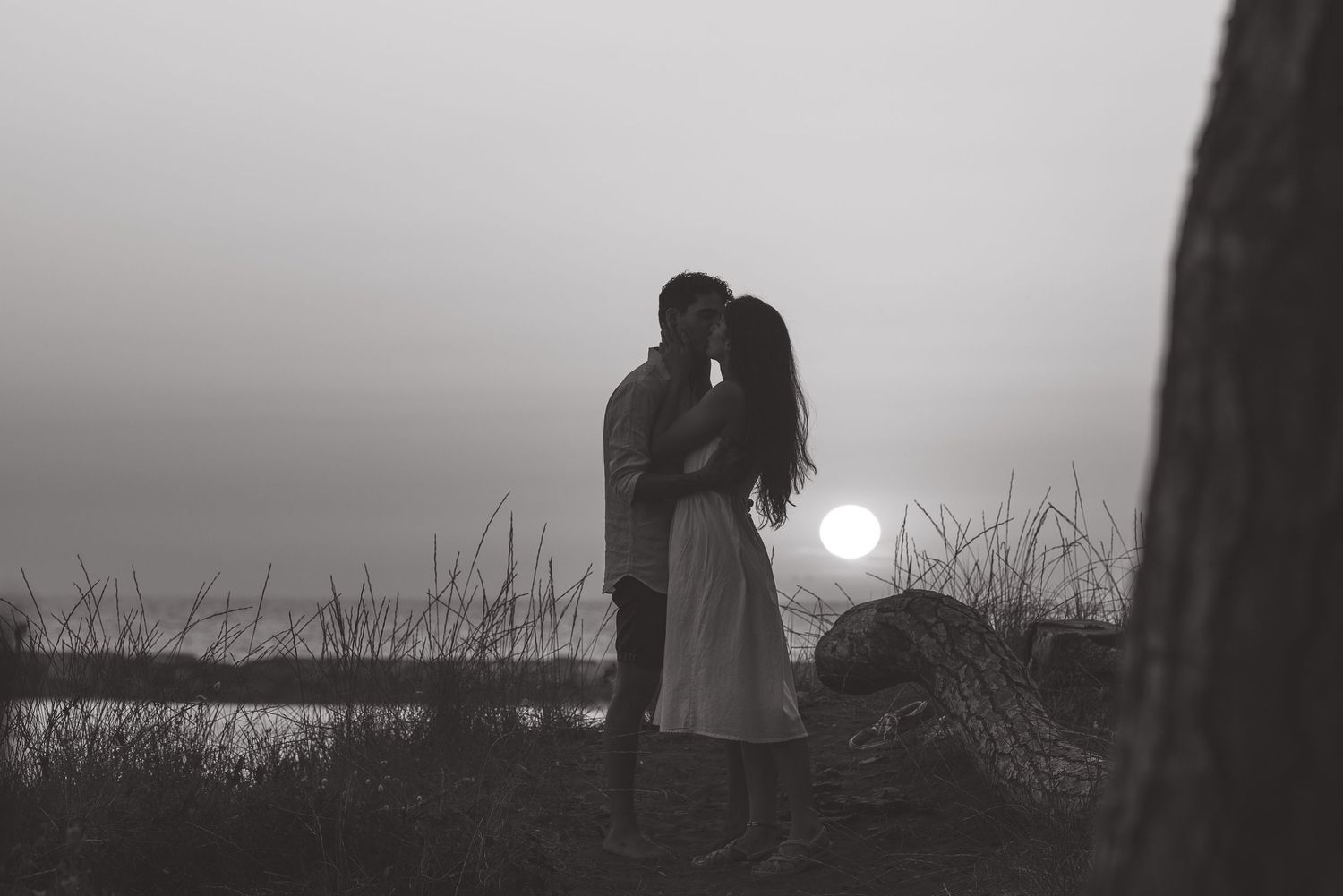 Romantic sunset portrait of a couple by the sea, evoking intimacy and soft golden-hour light. Ideal for destination weddings in Italy.