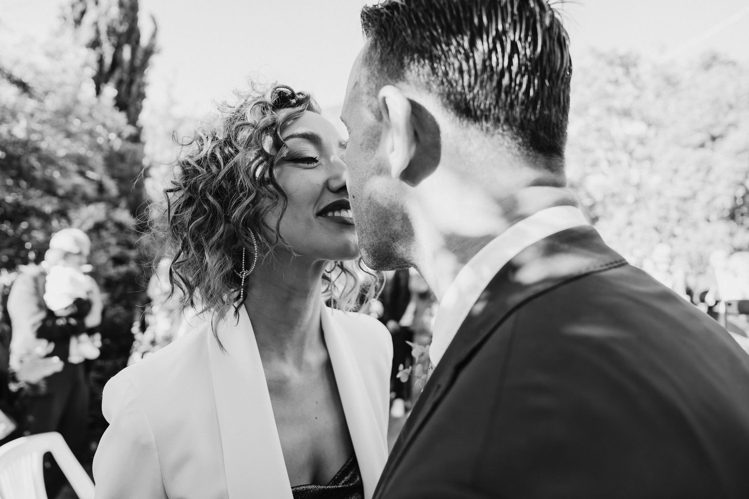 A candid black and white photo capturing an intimate moment between a couple.