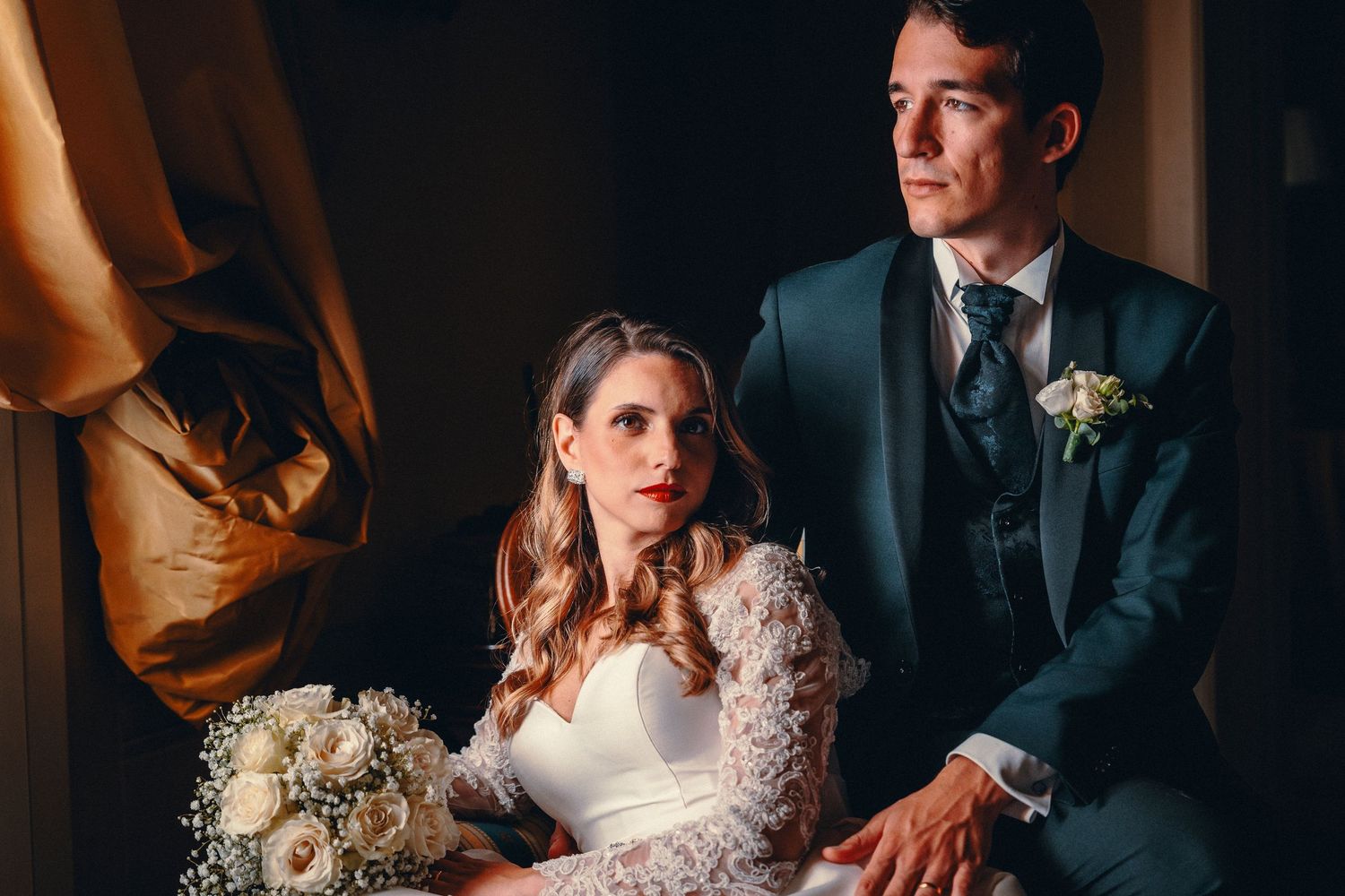 Dramatic wedding portrait with moody lighting and elegant formal attire.