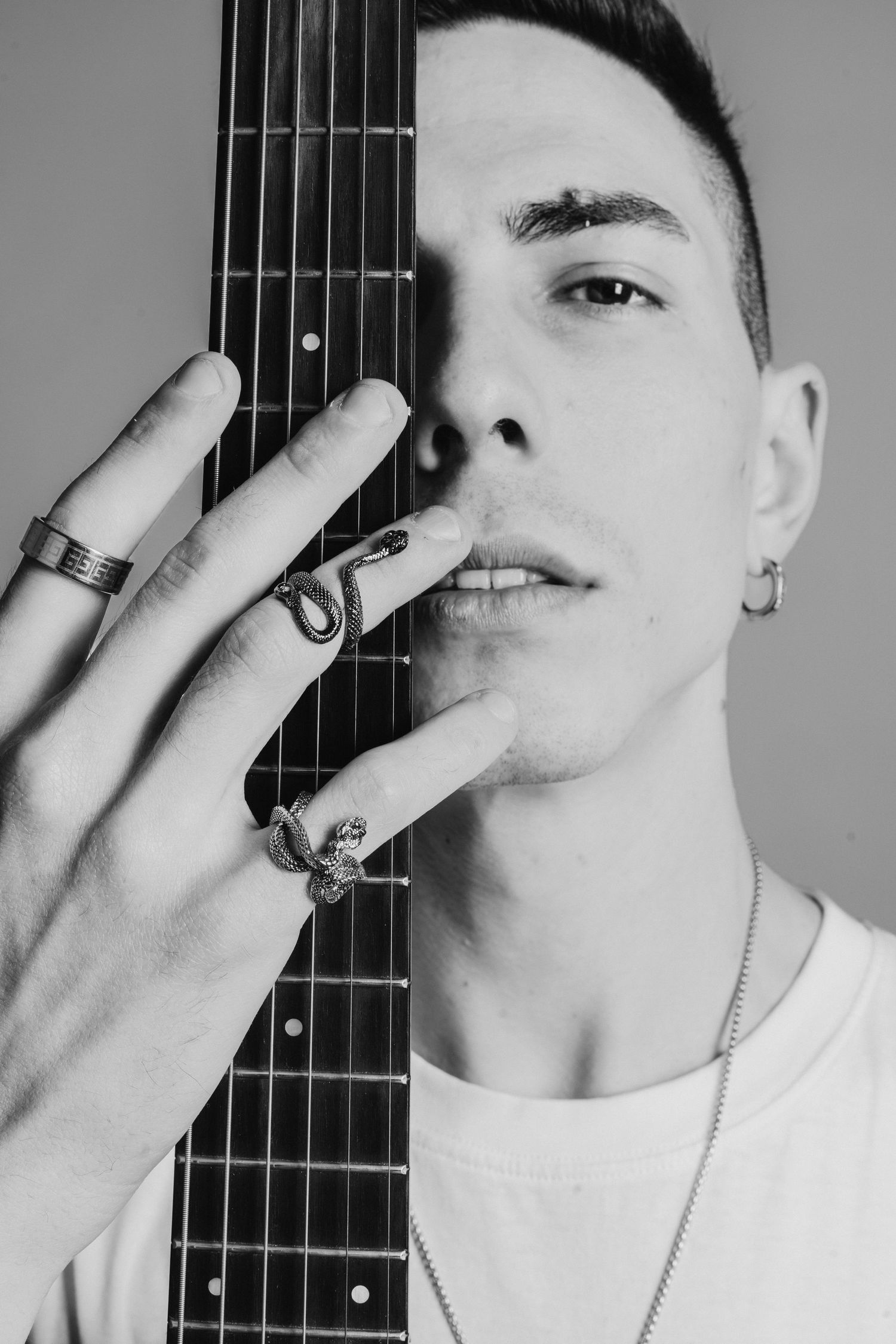 Artistic black and white photo series with guitar neck and rings on fingers.