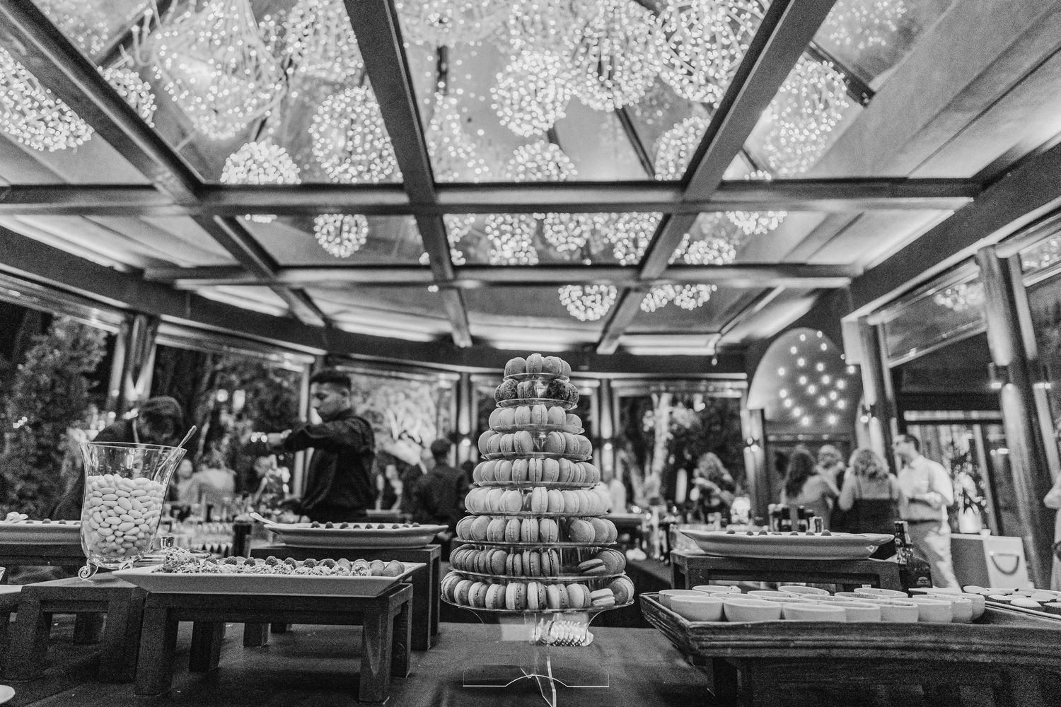 Black and white photo of a wedding reception venue with tiered cake display and dining tables.