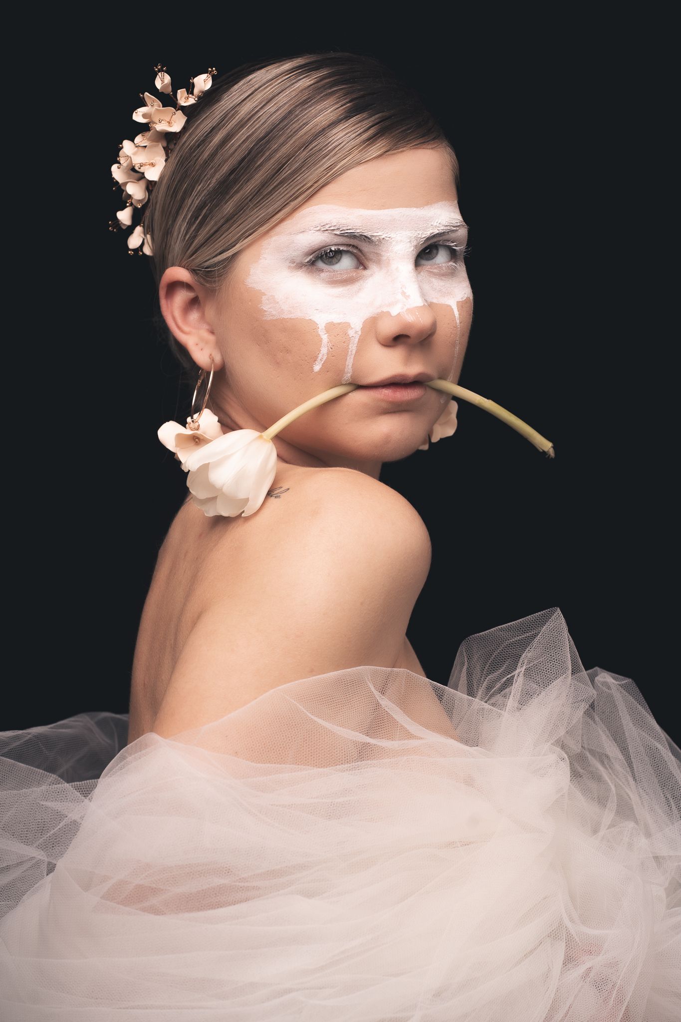 Studio portrait of a bride styled with roses and modern accessories. Contemporary bridal photography with editorial inspiration.