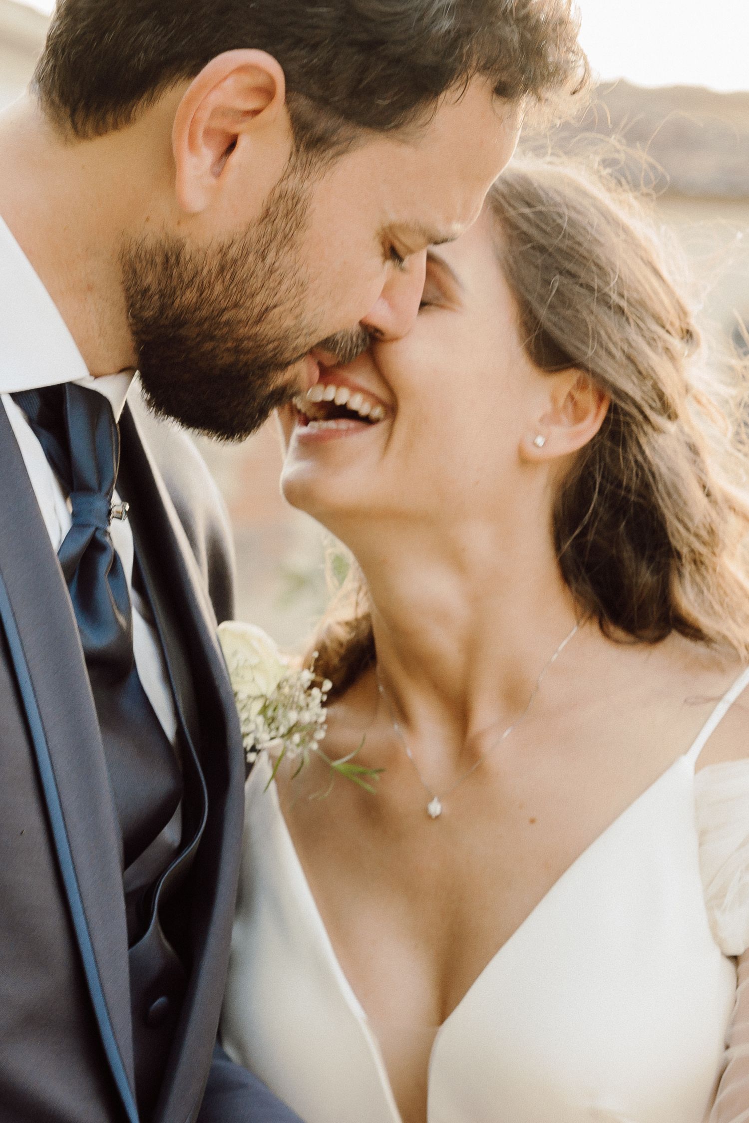 Intimate wedding portrait of couple sharing tender moment at sunset.