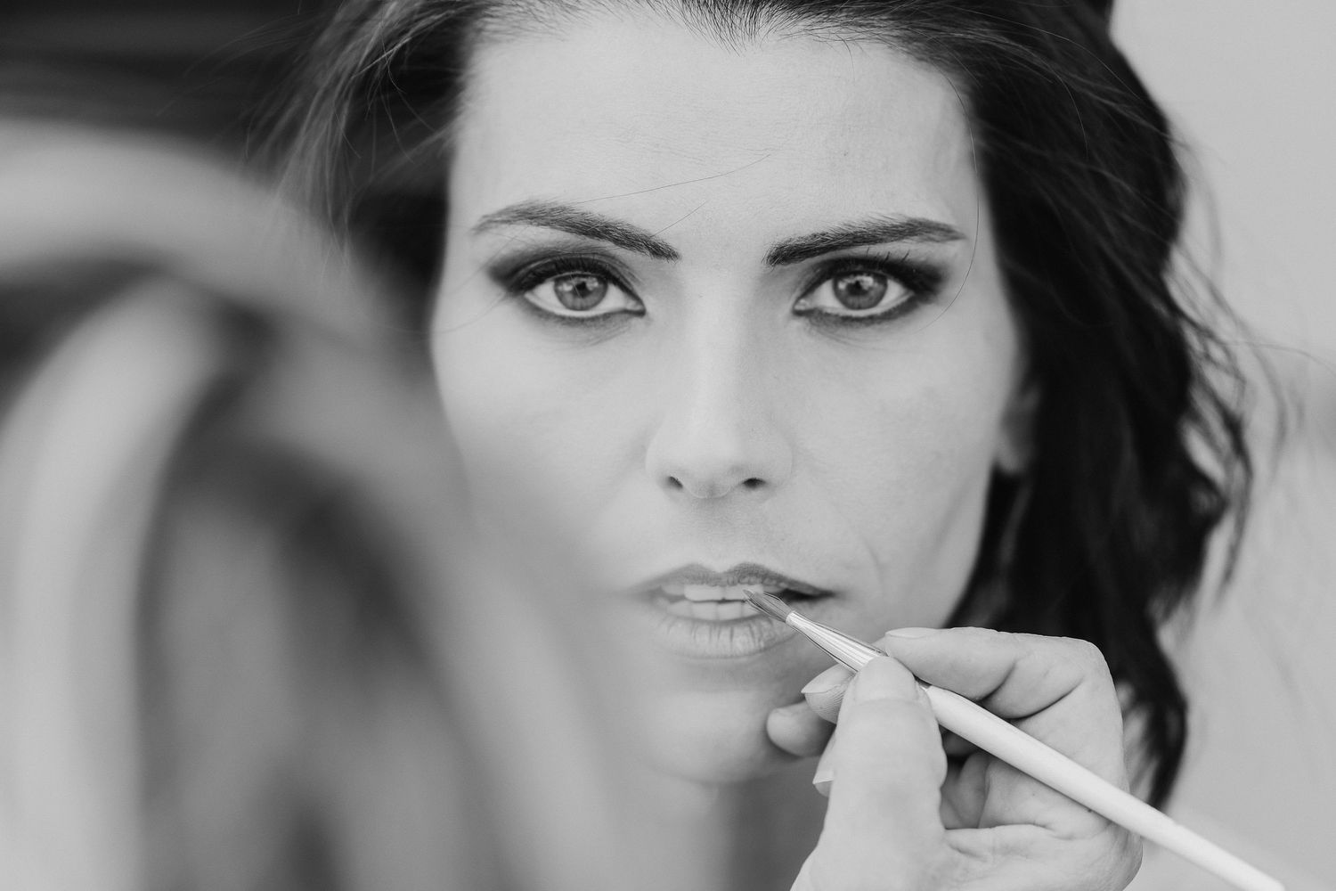 Close-up black and white beauty shot of applying makeup.