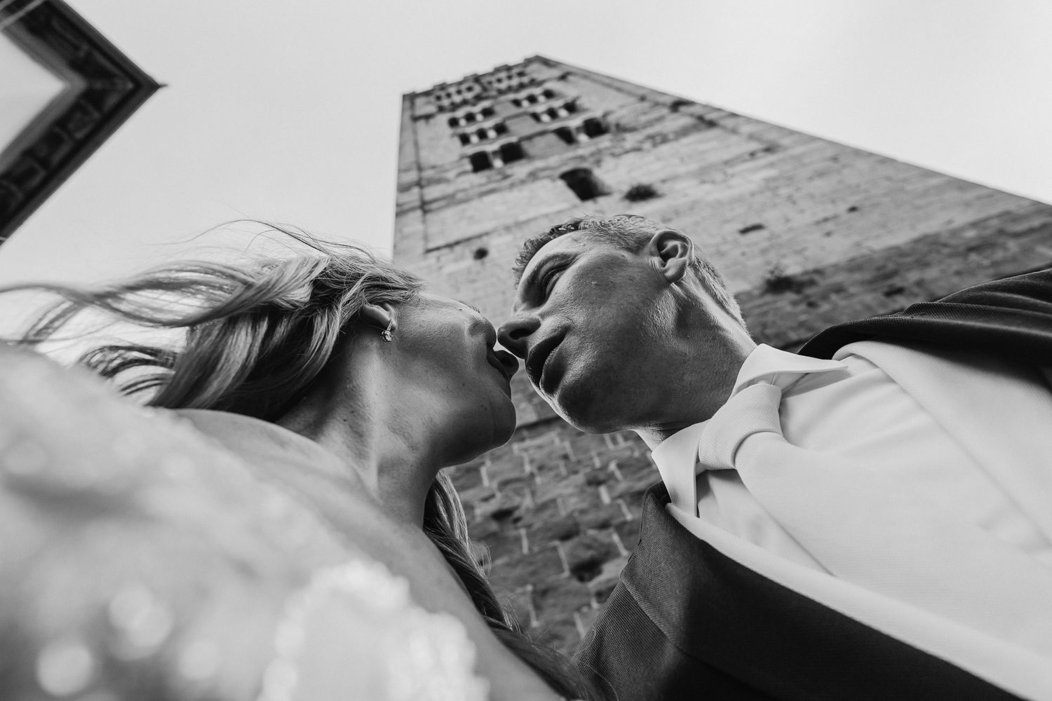 An intimate black and white close-up shot of a couple from a low angle.
