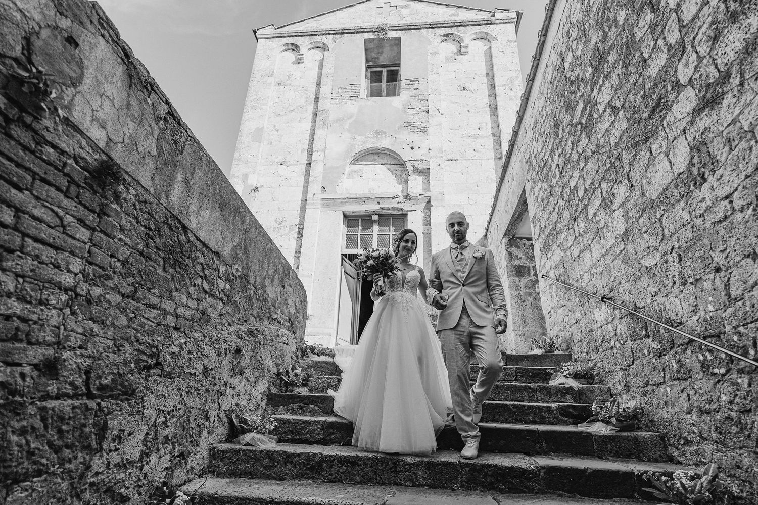 Intimate shot of the bride and groom exchanging vows outside a church. Authentic and sacred wedding moment.