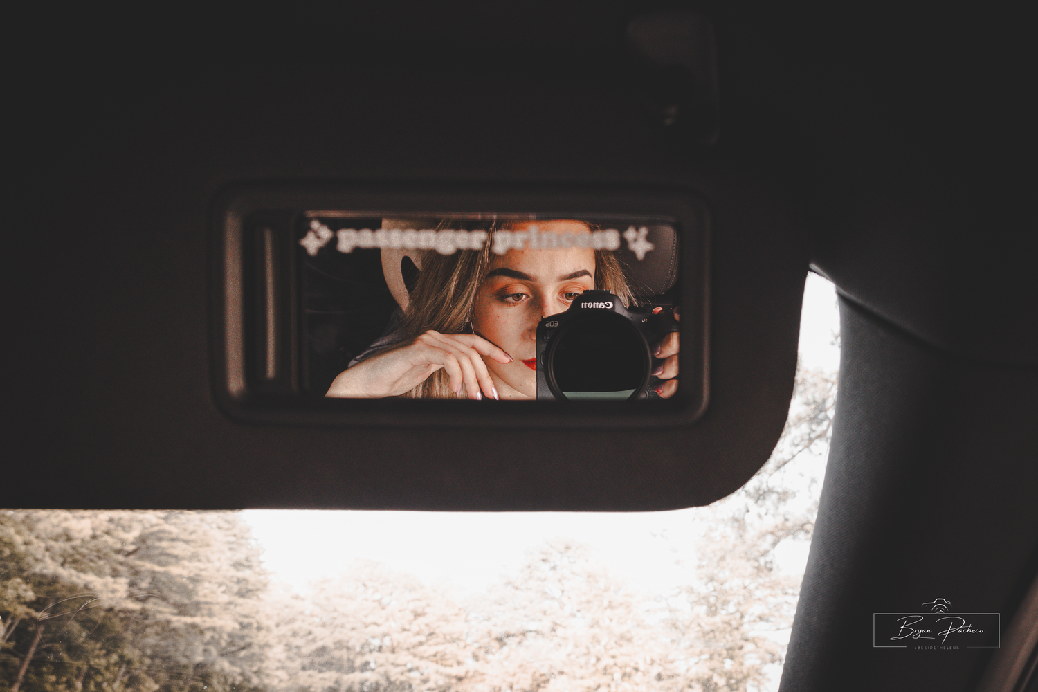 A side mirror reflection while driving shows a car interior and rear window view through a matte filter.