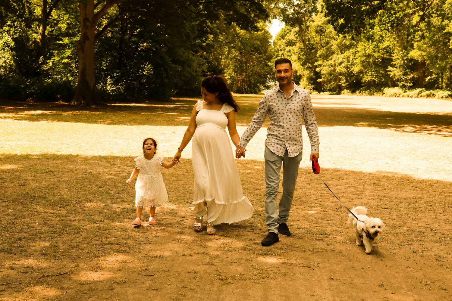 children laughing and running in Moor Park woodland during a family session with natural, emotive style