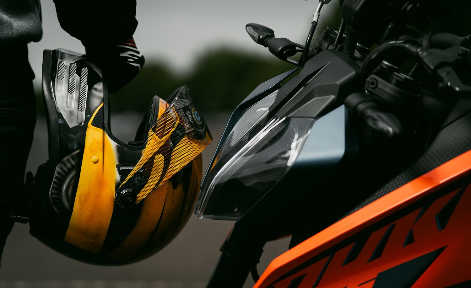 Atmospheric montage of motorcycle parts showing black and orange elements in a dark moody composition.