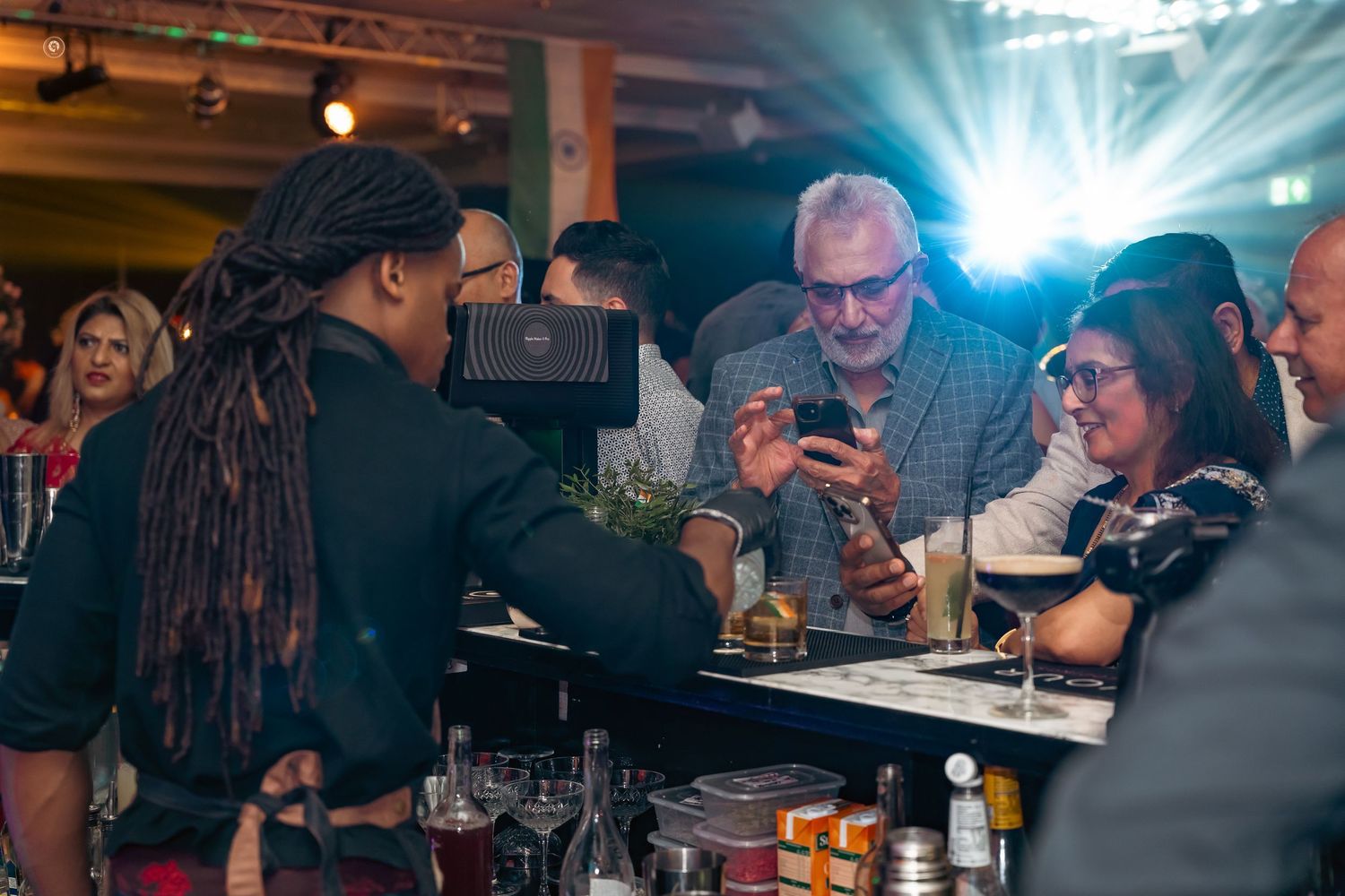 A group of people enjoying dinner and drinks at a dimly lit restaurant table.