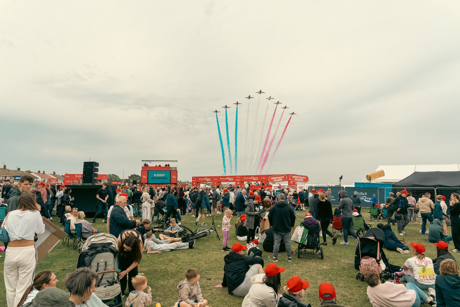 A series of outdoor festival scenes showing crowds gathered under cloudy skies with colorful aerial displays.