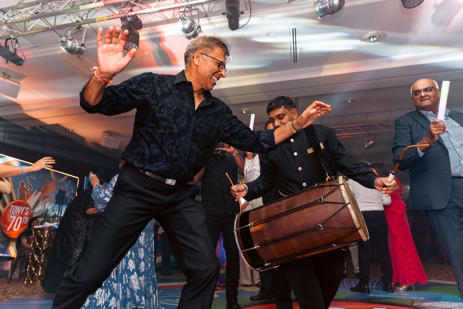 Guests dancing and celebrating on a cruise ship dance floor with colorful lighting and festive atmosphere.