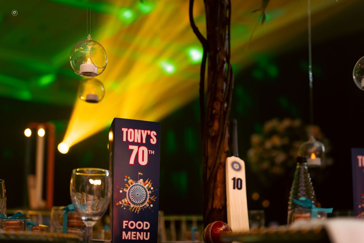 Colorful green and yellow stage lights illuminate a dark performance venue creating a dramatic atmosphere.