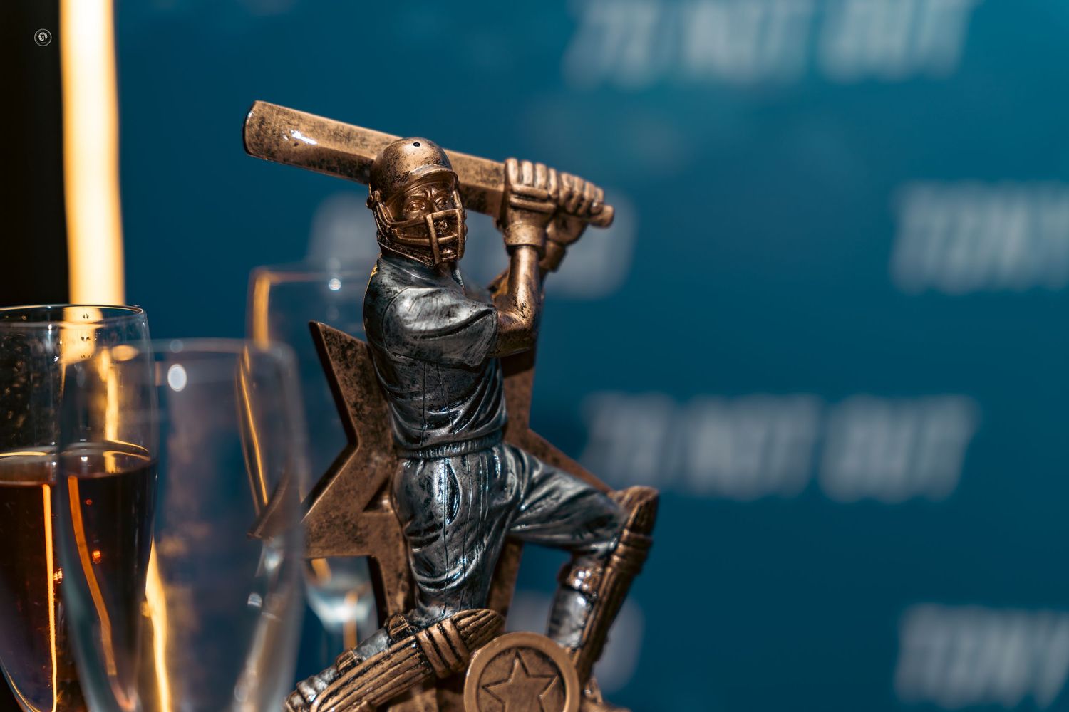 Bronze sports trophy statue of a basketball player in dynamic dribbling pose against a dark background.