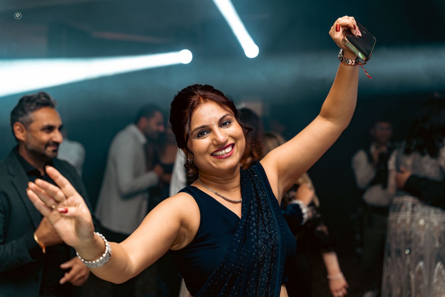 People dancing and having fun at a lively nightclub with bright lighting and energetic atmosphere.
