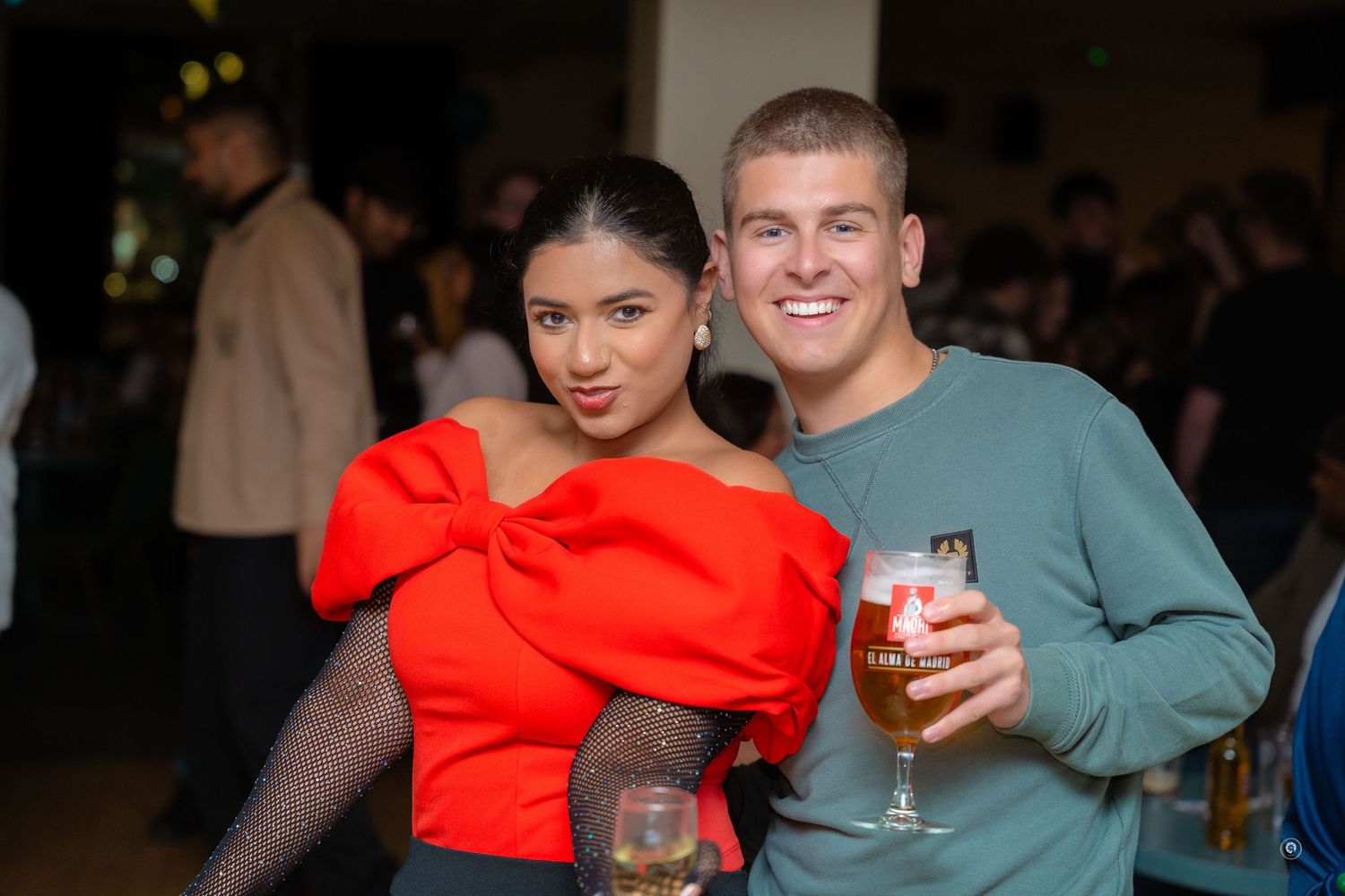 People enjoying drinks and socializing at a dimly lit bar or party venue.