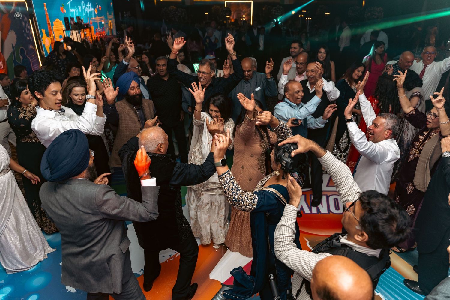 A crowded dance floor at a nightclub with people dancing under blue lighting and energetic atmosphere.