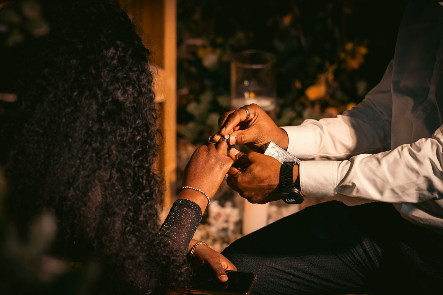 A couple shares an intimate dance moment at an outdoor wedding reception during golden hour.
