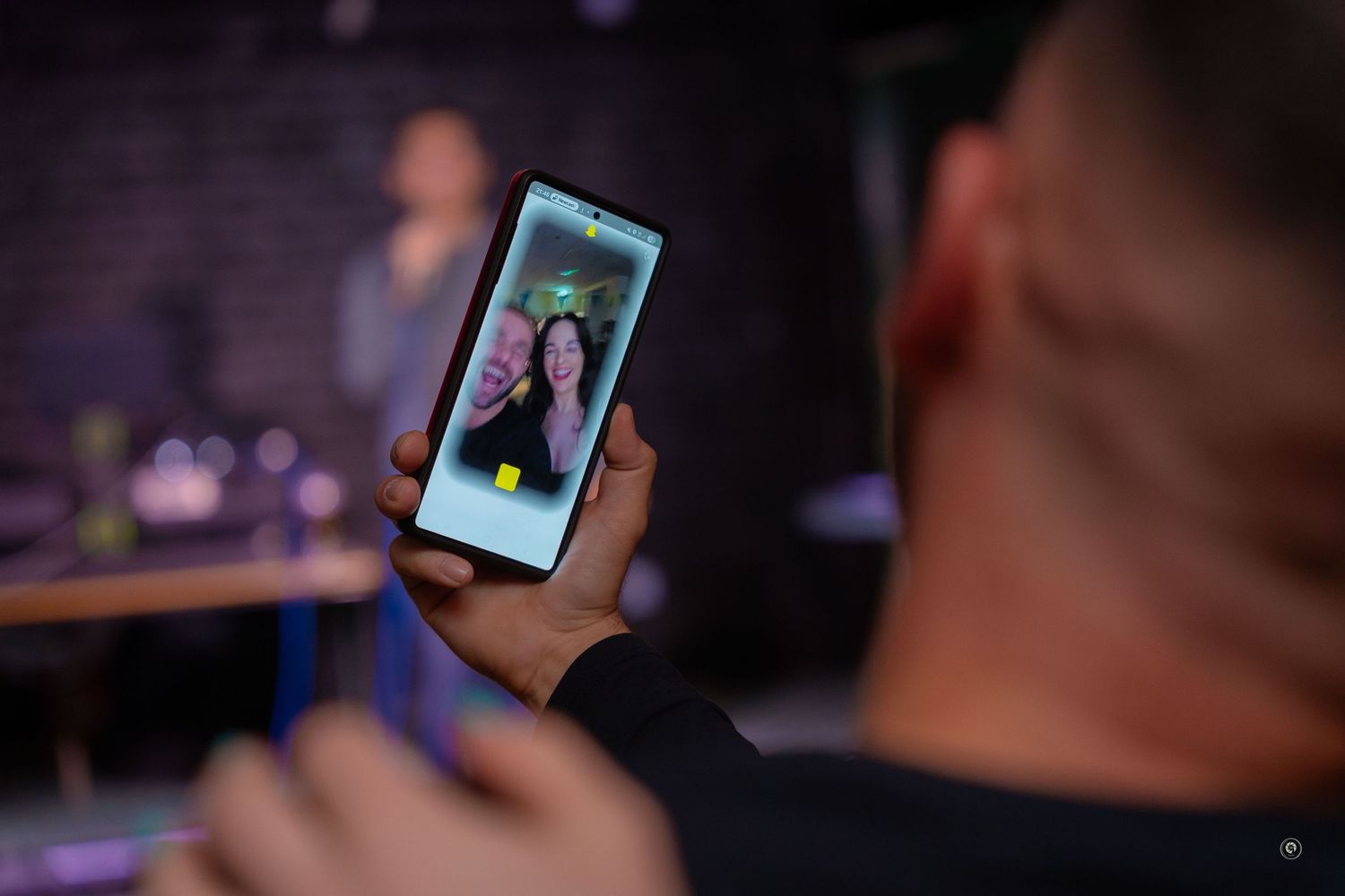 A sequence of seven photos showing someone holding a smartphone in a dimly lit setting.