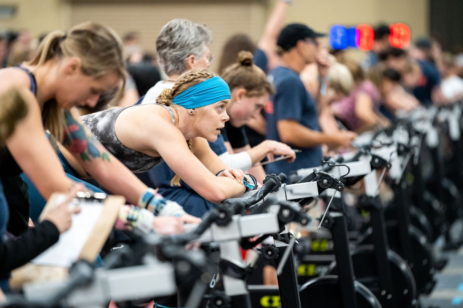 Athletes competing on multiple stationary bikes in an indoor cycling competition.