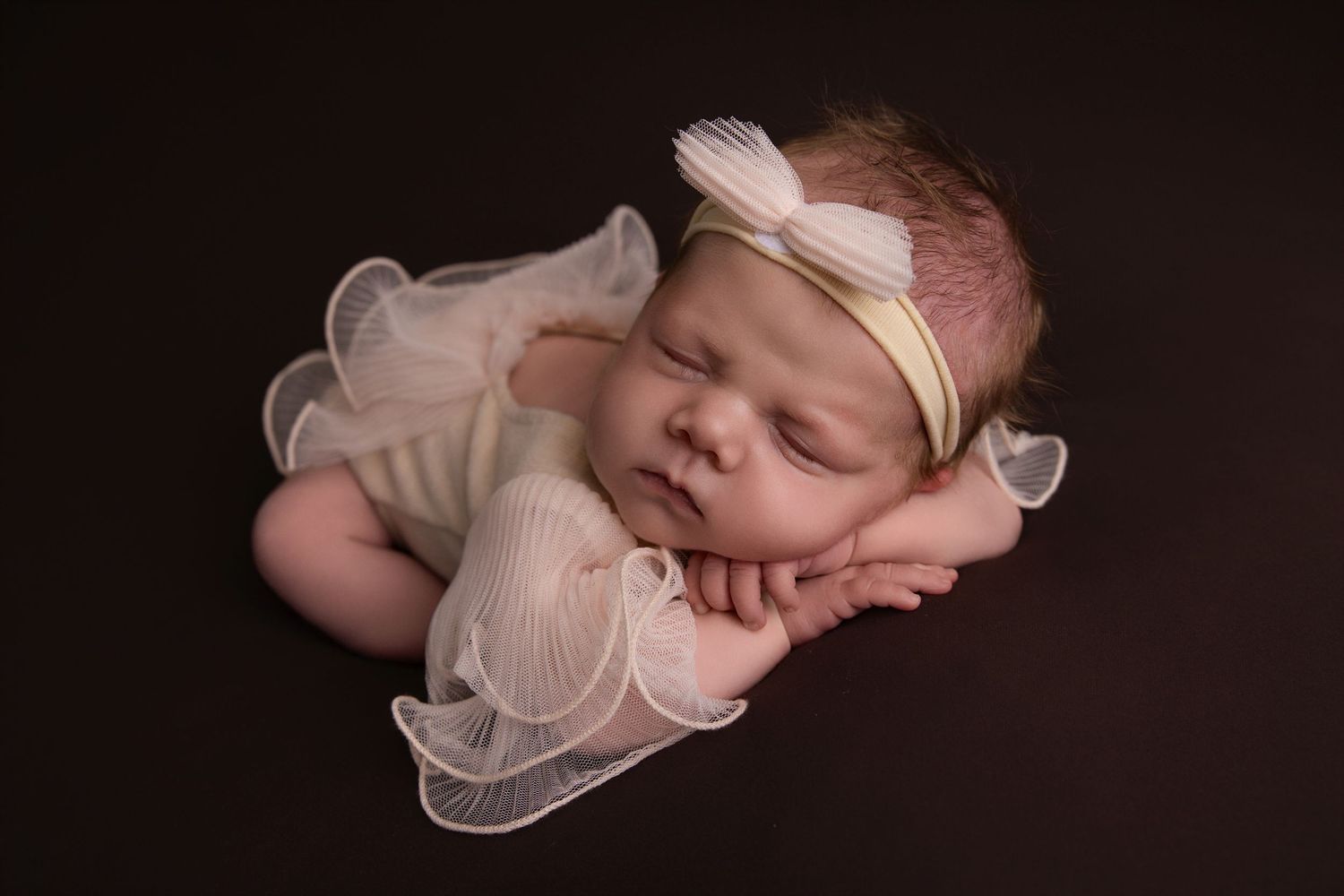 A collection of six connected photos showing a sleeping newborn baby in soft pink and beige tones.