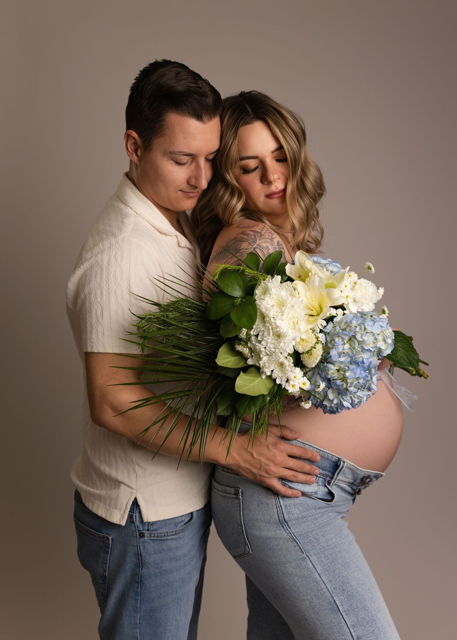 Salt Lake City maternity photographer - A tender maternity photo featuring a couple holding a bouquet of white and blue hydrangeas