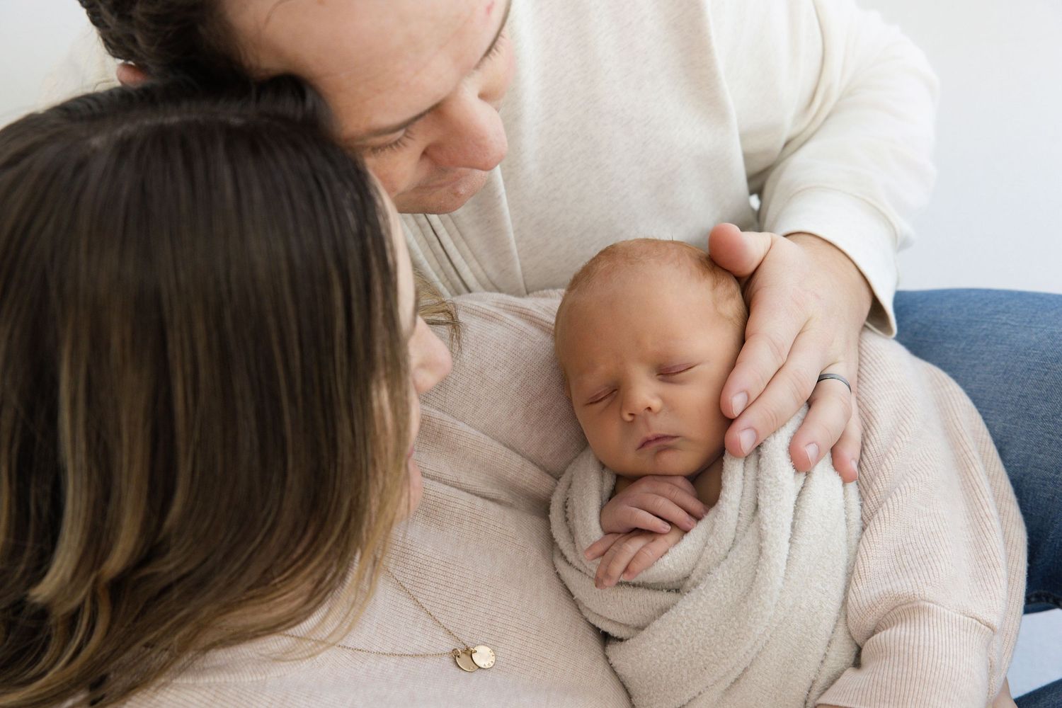 A series of intimate newborn photography portraits showing tender moments between parent and baby in soft neutral tones.